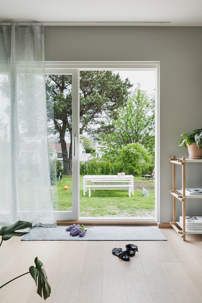 Helle Diele mit Heymat Fußmatte Hagl in Grau vor einer offenen Terrassentür zum Garten.