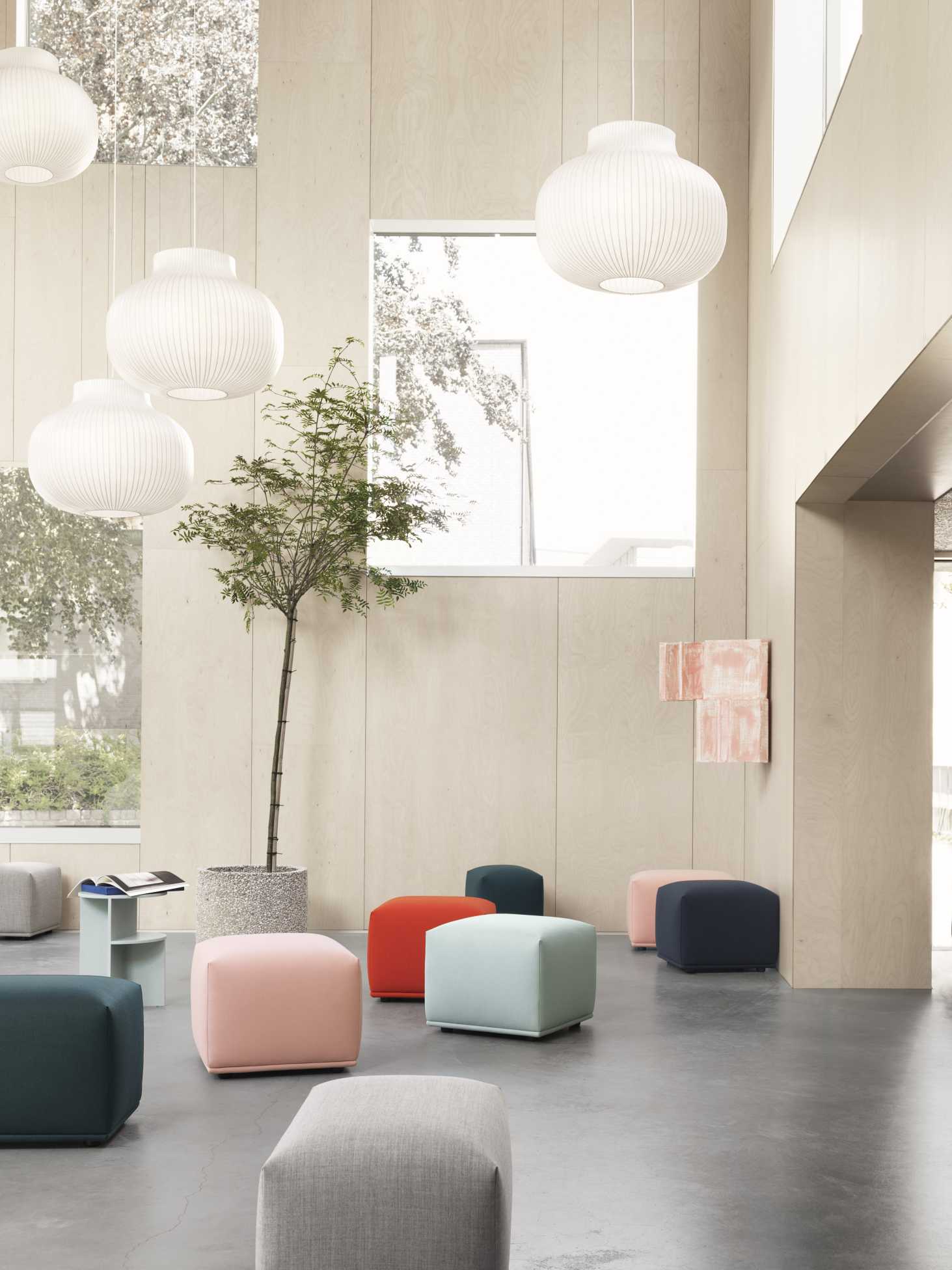 Helle Muuto Strand Pendelleuchten über farbigen Hockern in modernem, minimalistischem Interieur.