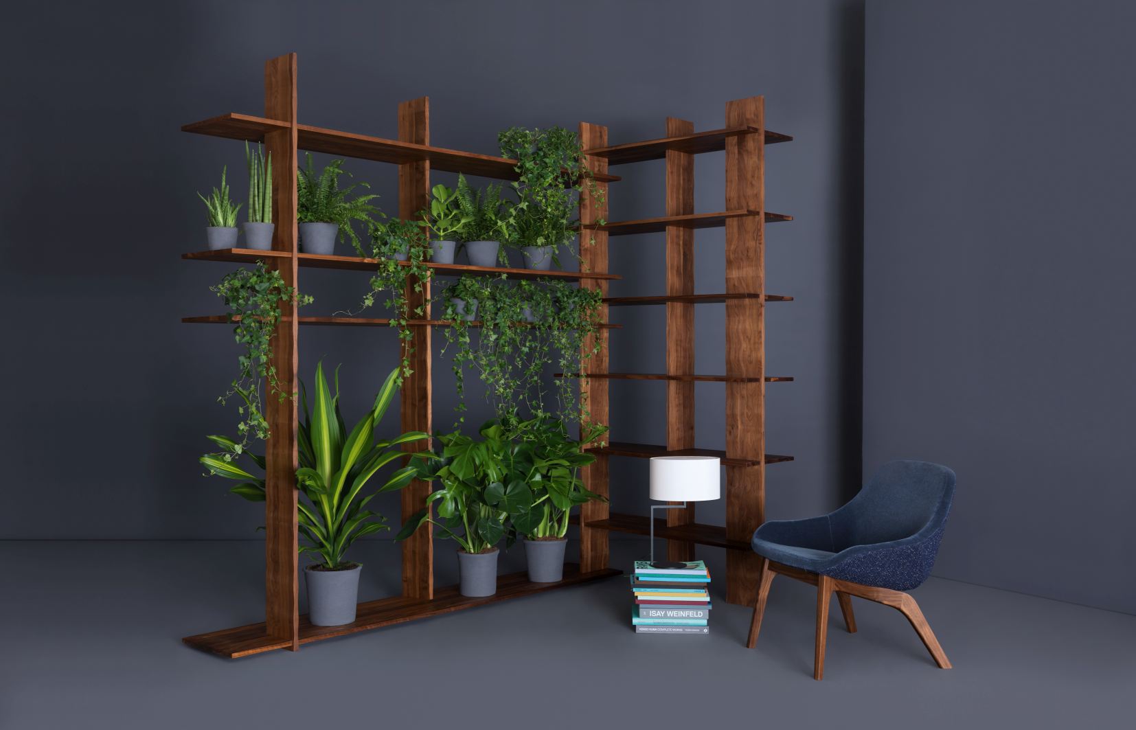 Morph Lounge Chair Sessel: Blauer Sessel mit Holzbeinen vor einem Regal mit Pflanzen.