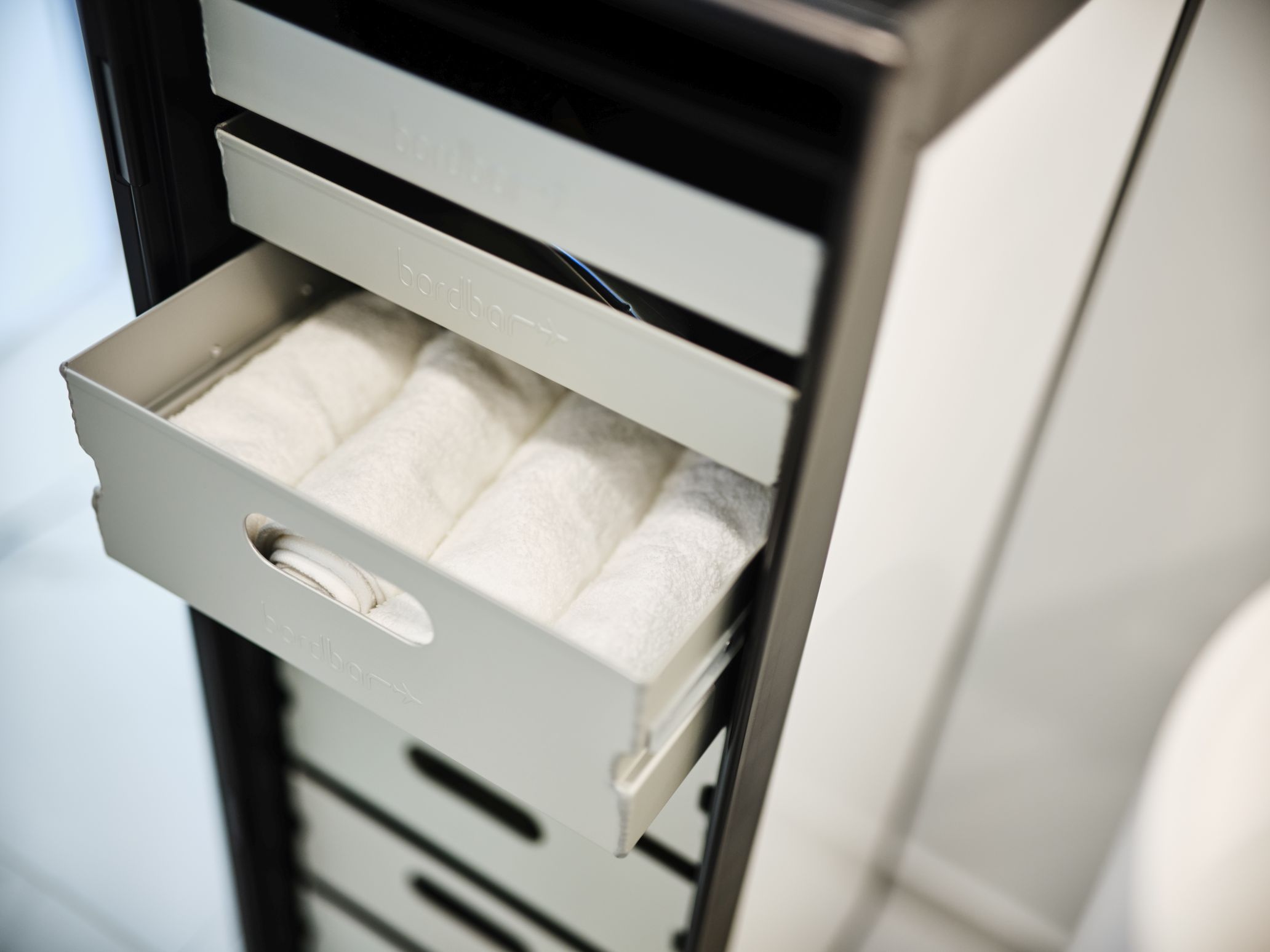 Storage Equipment Set Bordbar Zubehör: Auszug mit gerollten, weißen Handtüchern in einem Bordbar-Schrank.
