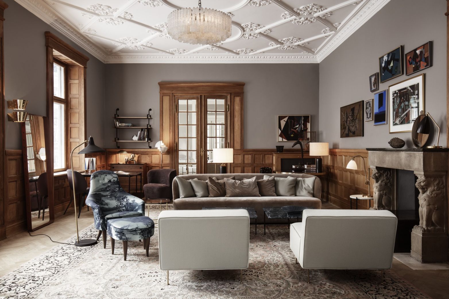 Elegantes Wohnzimmer mit Gubi Adnet Spiegel, Sofa, Sesseln und dekorativem Kamin.