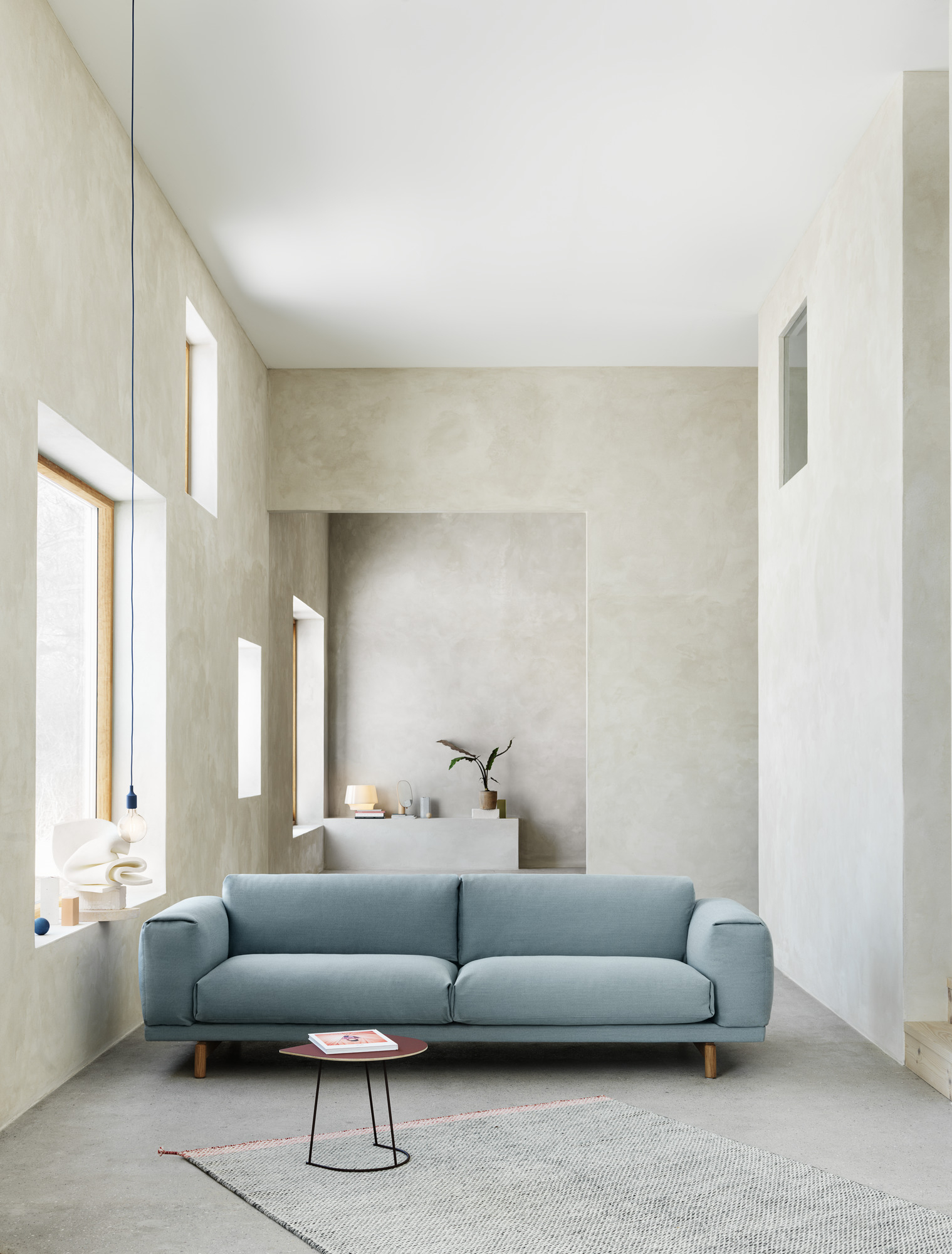 Moderner Wohnraum mit blauem Sofa und kleinem, runden Airy Coffee Table Beistelltisch von Muuto.
