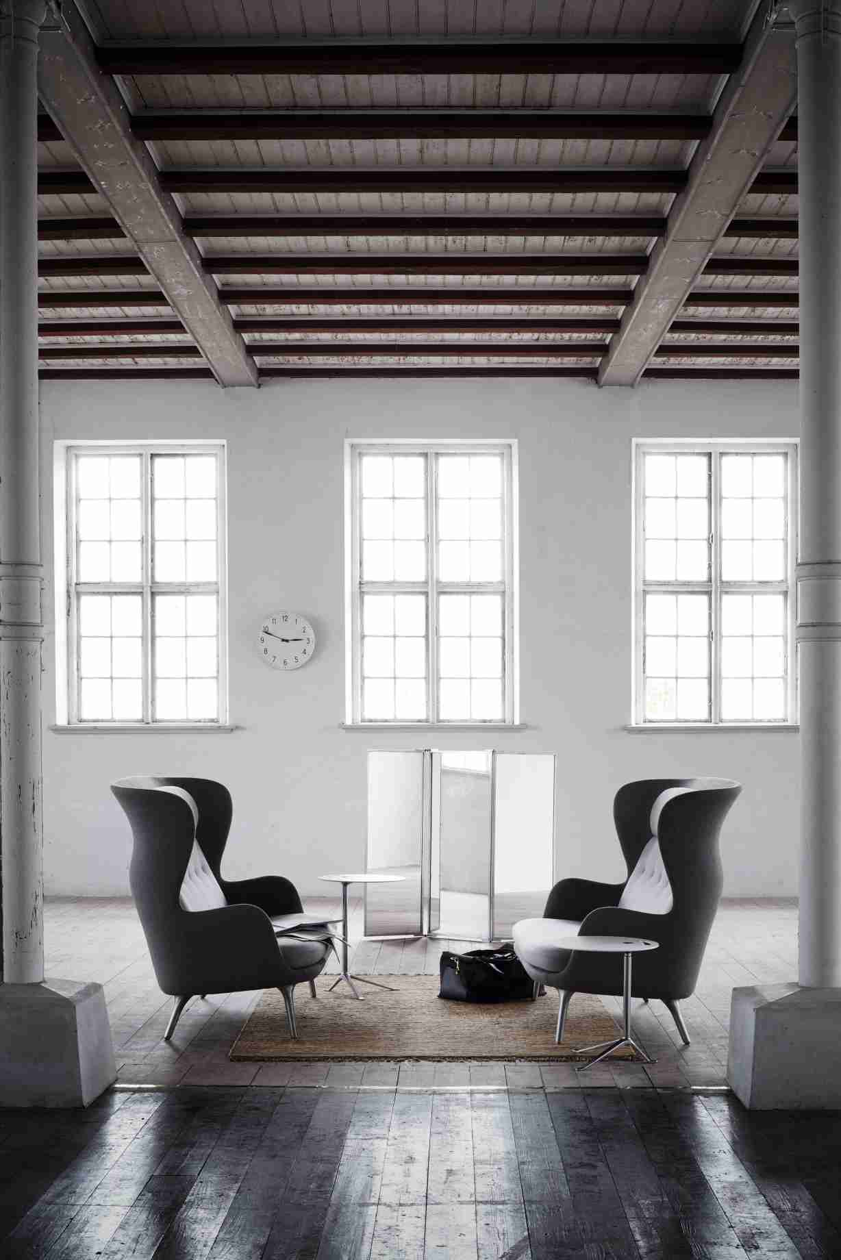 Zwei Fritz Hansen Ro Sessel in grau mit Beistelltischen in einem hellen, modernen Loft.