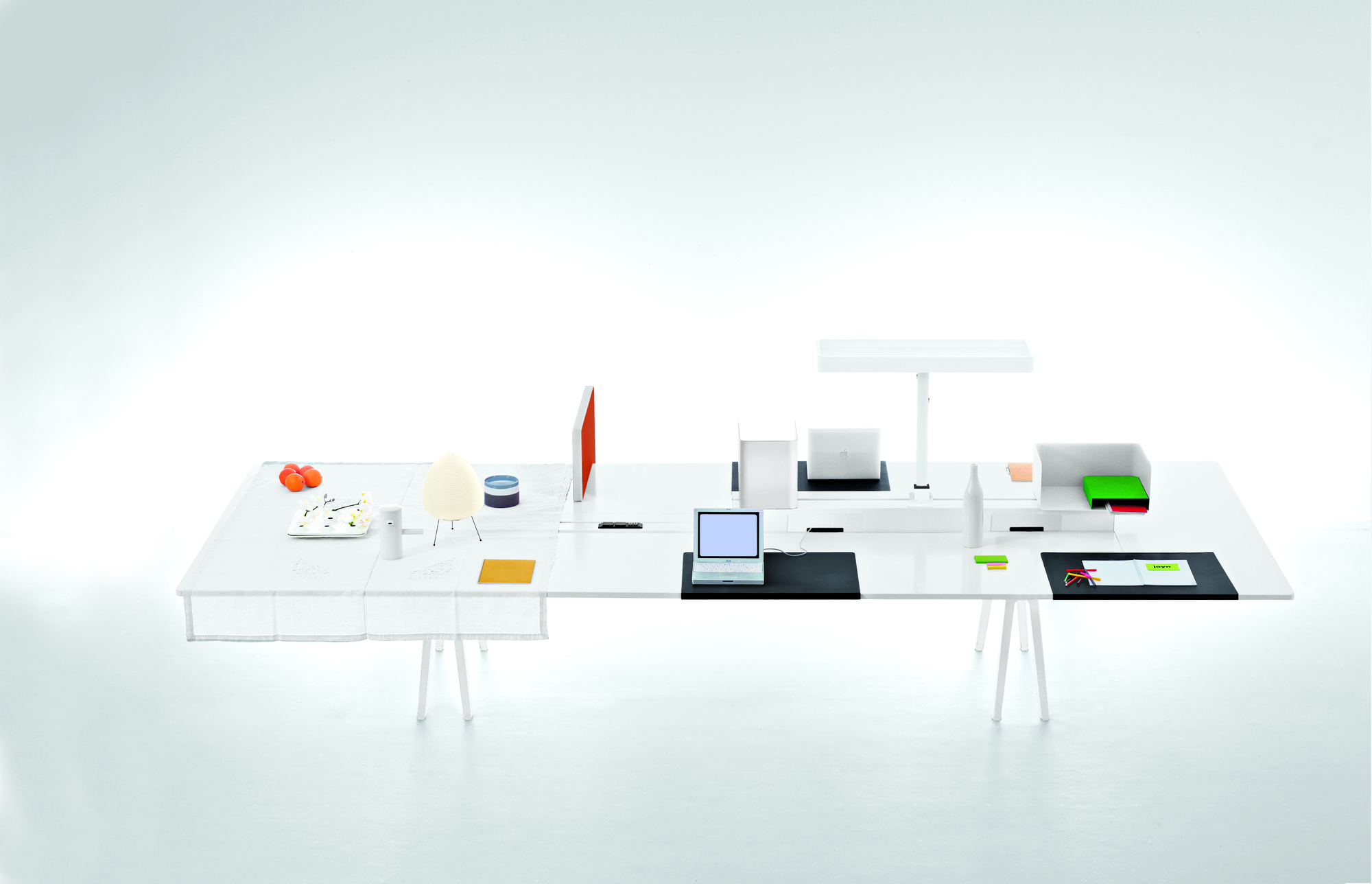 Vitra Joyn Schreibtischunterlage: Großzügiger, weißer Bürotisch mit zwei Laptops, Lampe und Büro-Accessoires für modernes Arbeiten.