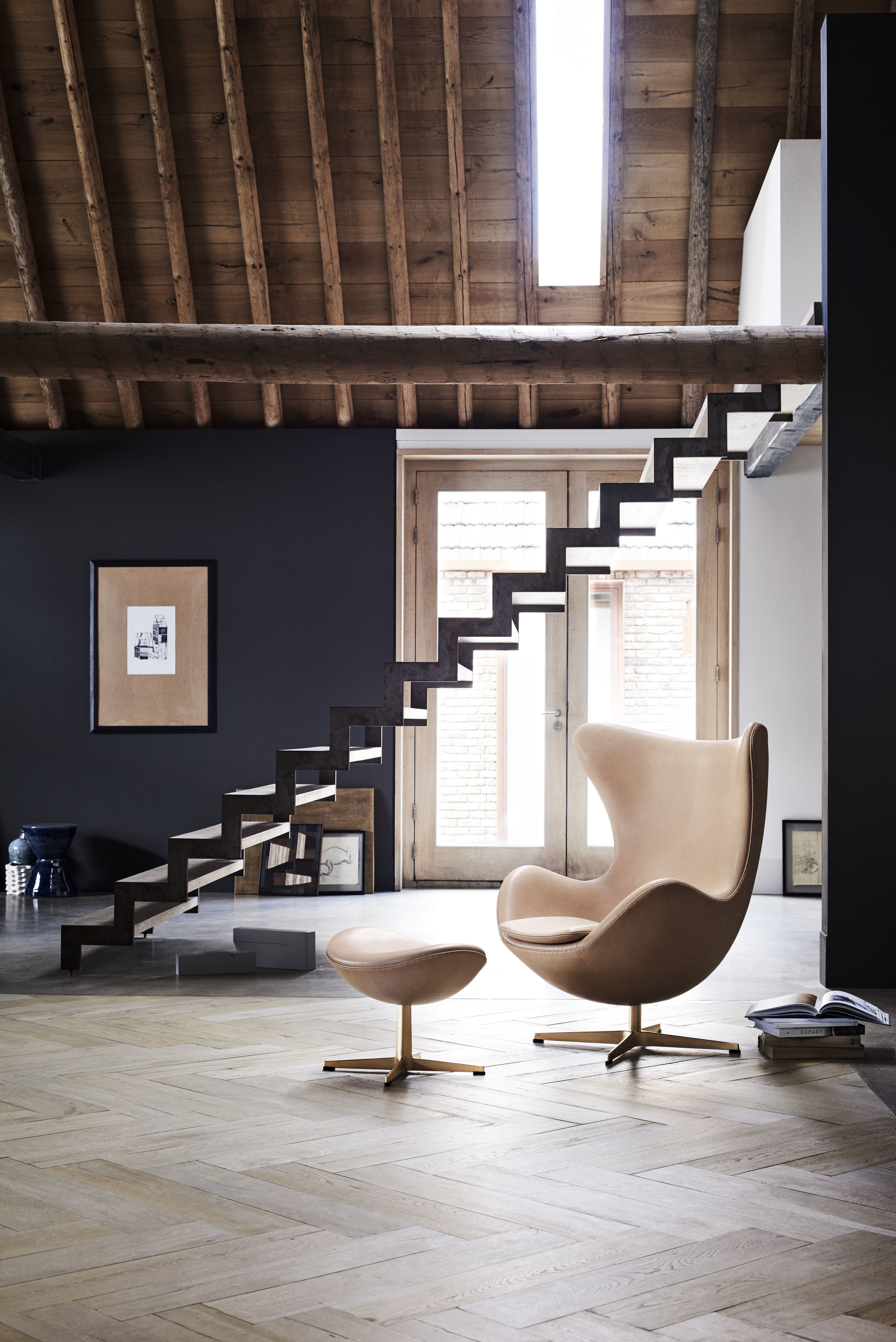 Beige "Das Ei" Sessel mit Hocker von Fritz Hansen in modernem Wohnzimmer mit Holztreppe.