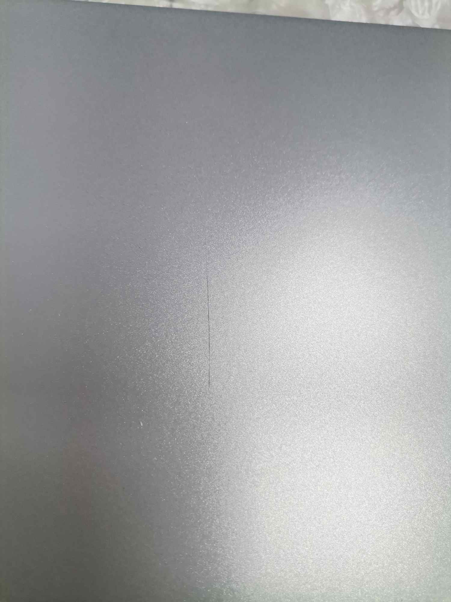 Detailaufnahme eines grauen USM Haller Ersatzteils mit einem feinen Kratzer, Mängelexemplar.