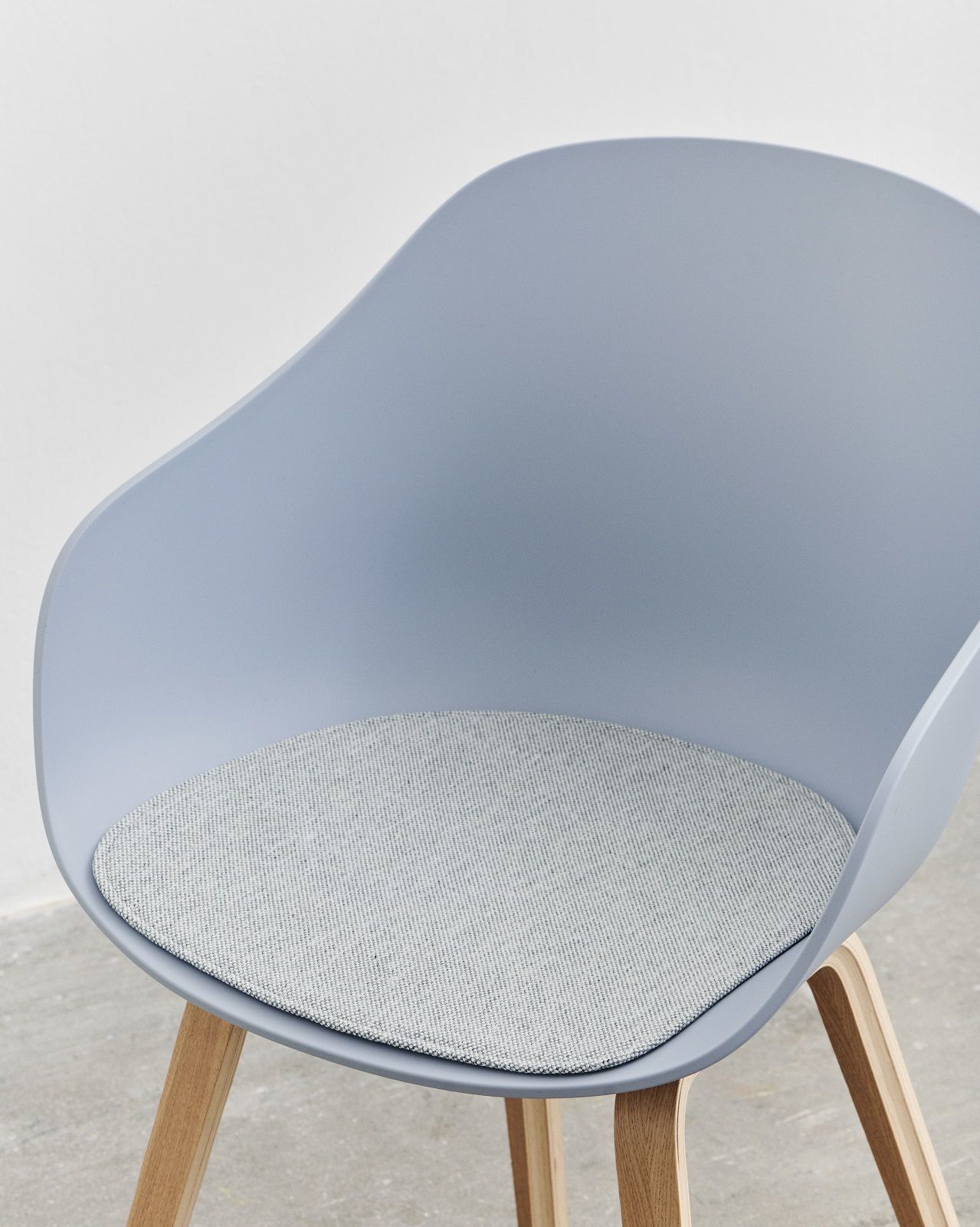Grauer About A Chair (AAC) Stuhl mit Armlehnen und passendem, grauem Seat Pad Sitzkissen.