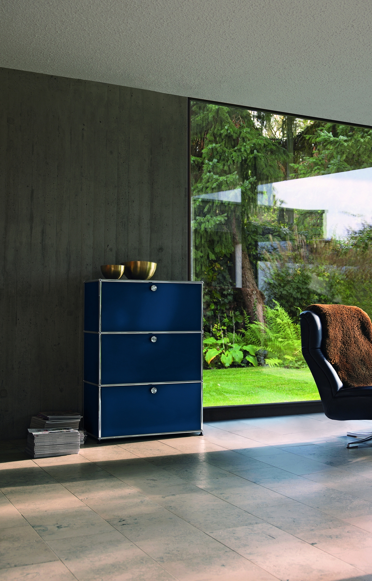 Blaues USM Haller Highboard mit drei Klappen im modernen Wohnzimmer mit großem Fenster.