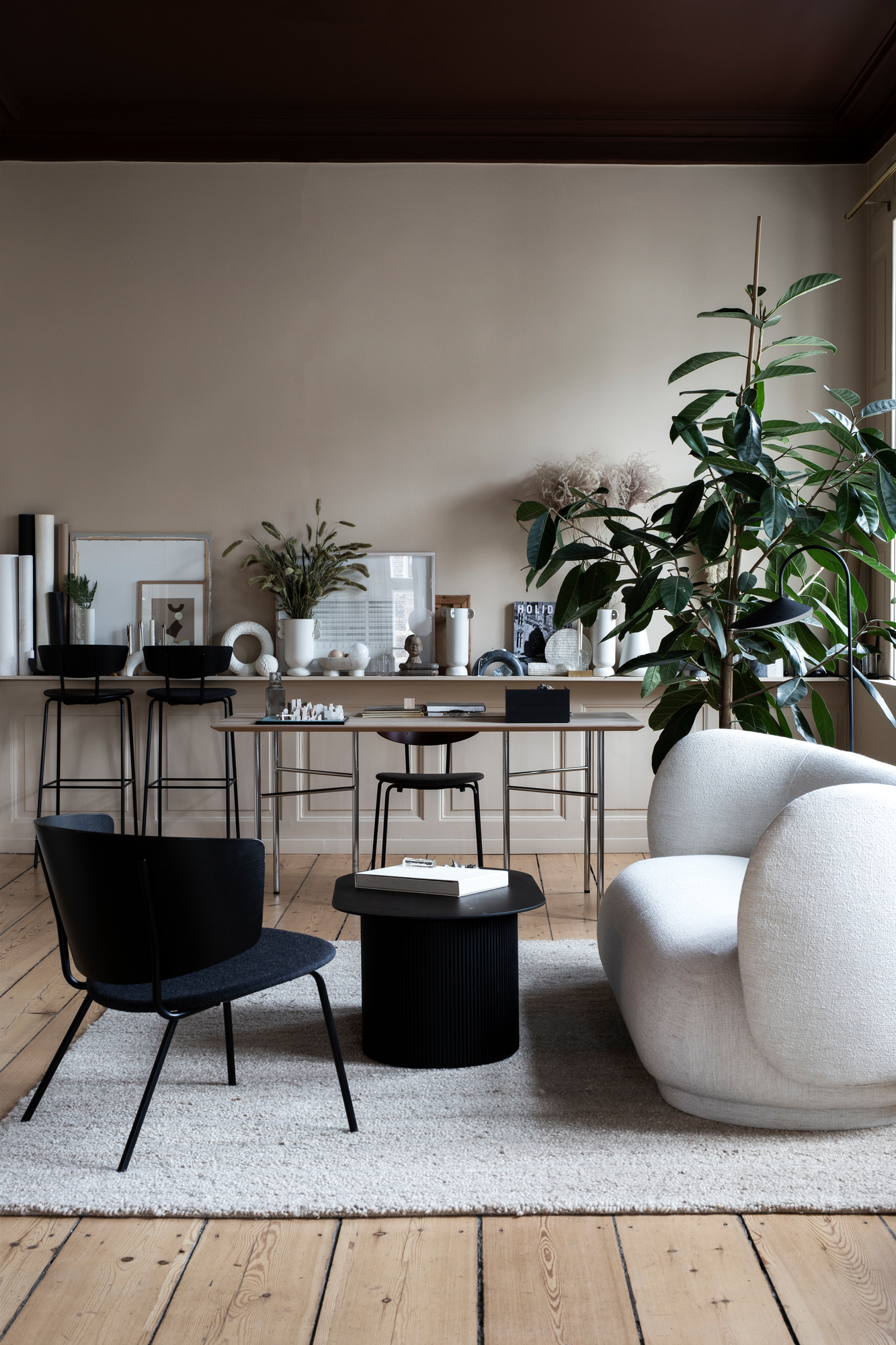 Weißer Rico Lounge Chair Sessel von Ferm Living in stilvollem Wohnzimmer mit Teppich.