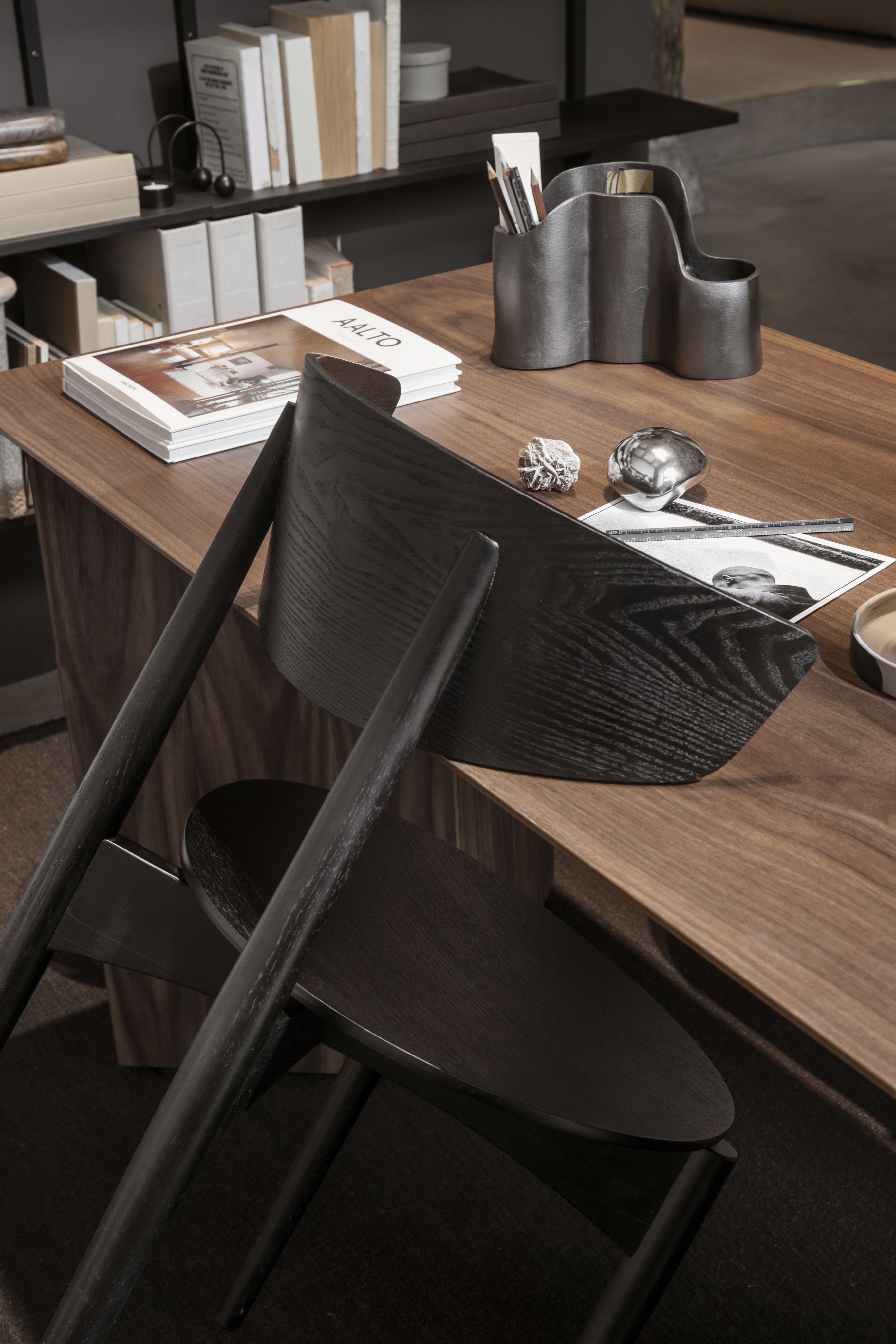 Rückansicht des Herman Esszimmerstuhls von Ferm Living mit schwarzem Holzgestell am Schreibtisch.