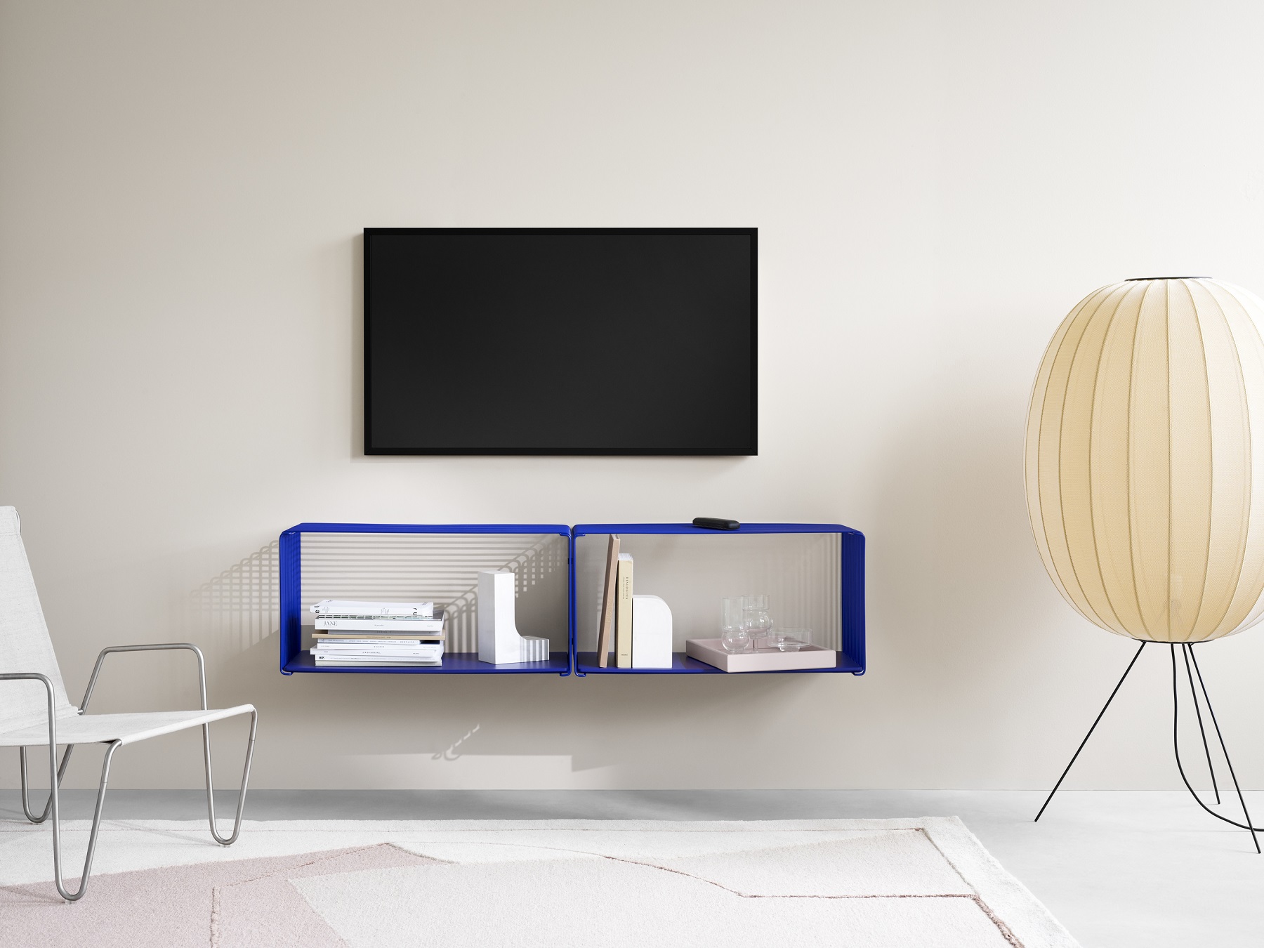 Blaues Panton Wire Regalsystem von Montana, modernes Wandregal mit Fächern im Wohnzimmer unter einem Fernseher.