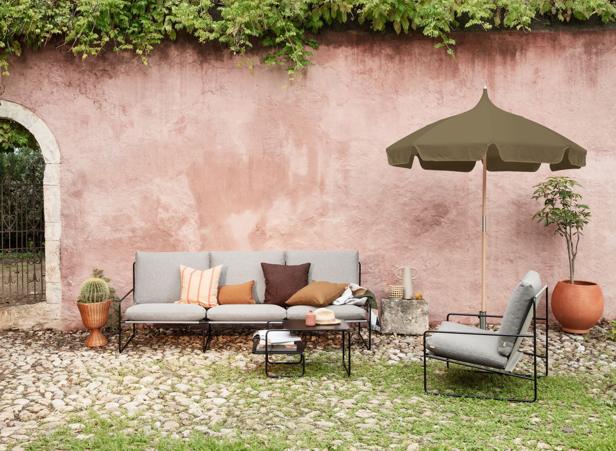 Desert 1-Sitzer Outdoor Sessel von Ferm Living mit schwarzem Gestell im Garten. Bequemer Loungesessel.