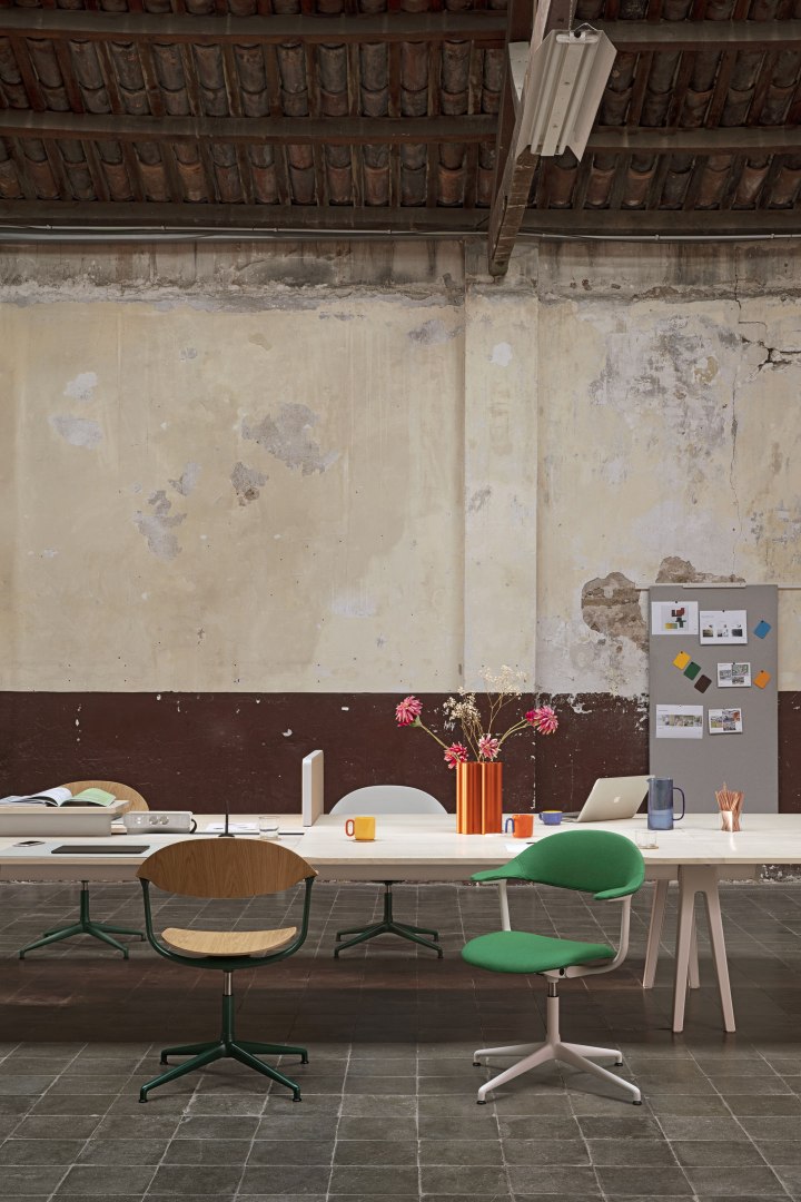 Mynt Bürodrehstuhl von Vitra mit Kunststoff-Sitz und Rückenlehne in Grün und Holz vor Schreibtisch.