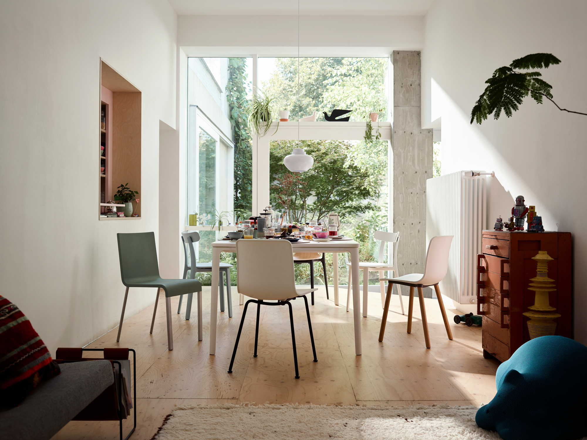 Esszimmer mit Esstisch und verschiedenen Hal Ply Wood Stühlen von Vitra in modernem Ambiente.