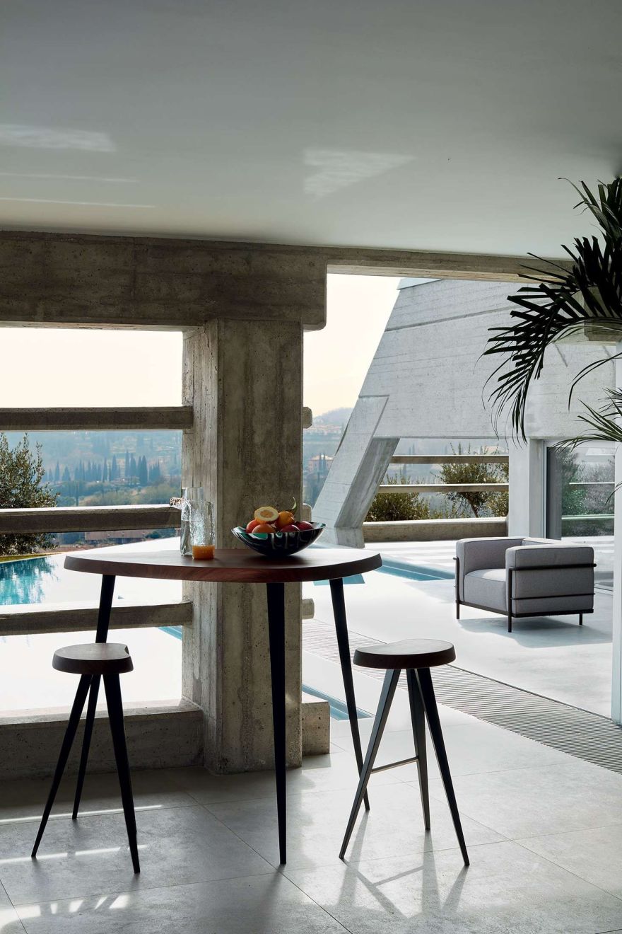 Innenaufnahme mit Cassina 3 Fauteuil Grand Confort Sessel, Tisch mit Obstschale und Hockern in modernem Ambiente.