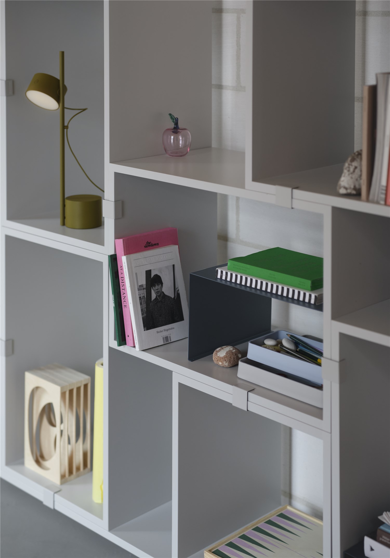 Nahaufnahme der Muuto Post Table Lamp Tischleuchte in Braun-Grün auf einem Regal.