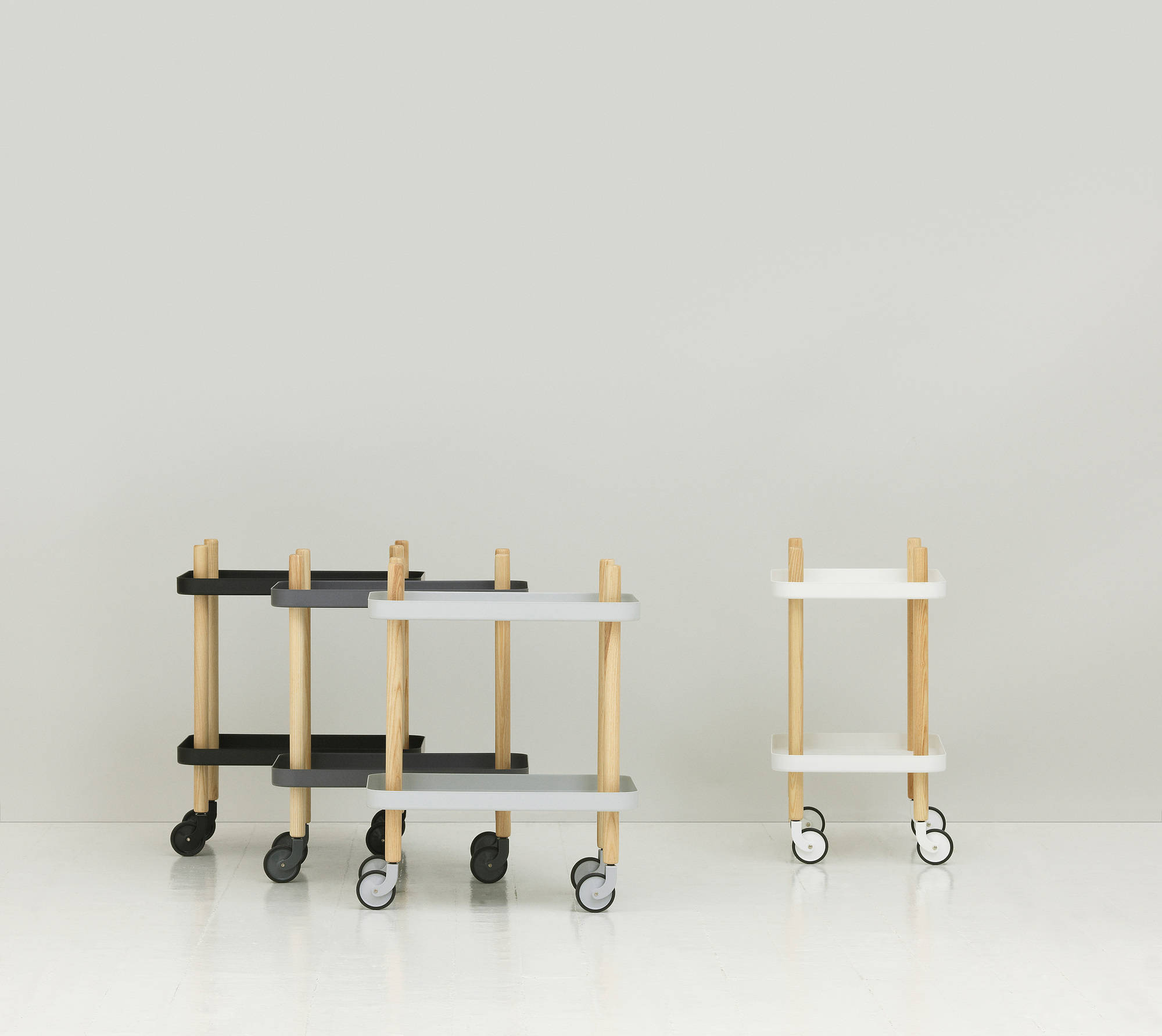 Normann Copenhagen Block Table Servierwagen in Schwarz, Grau und Weiß mit Holzbeinen.