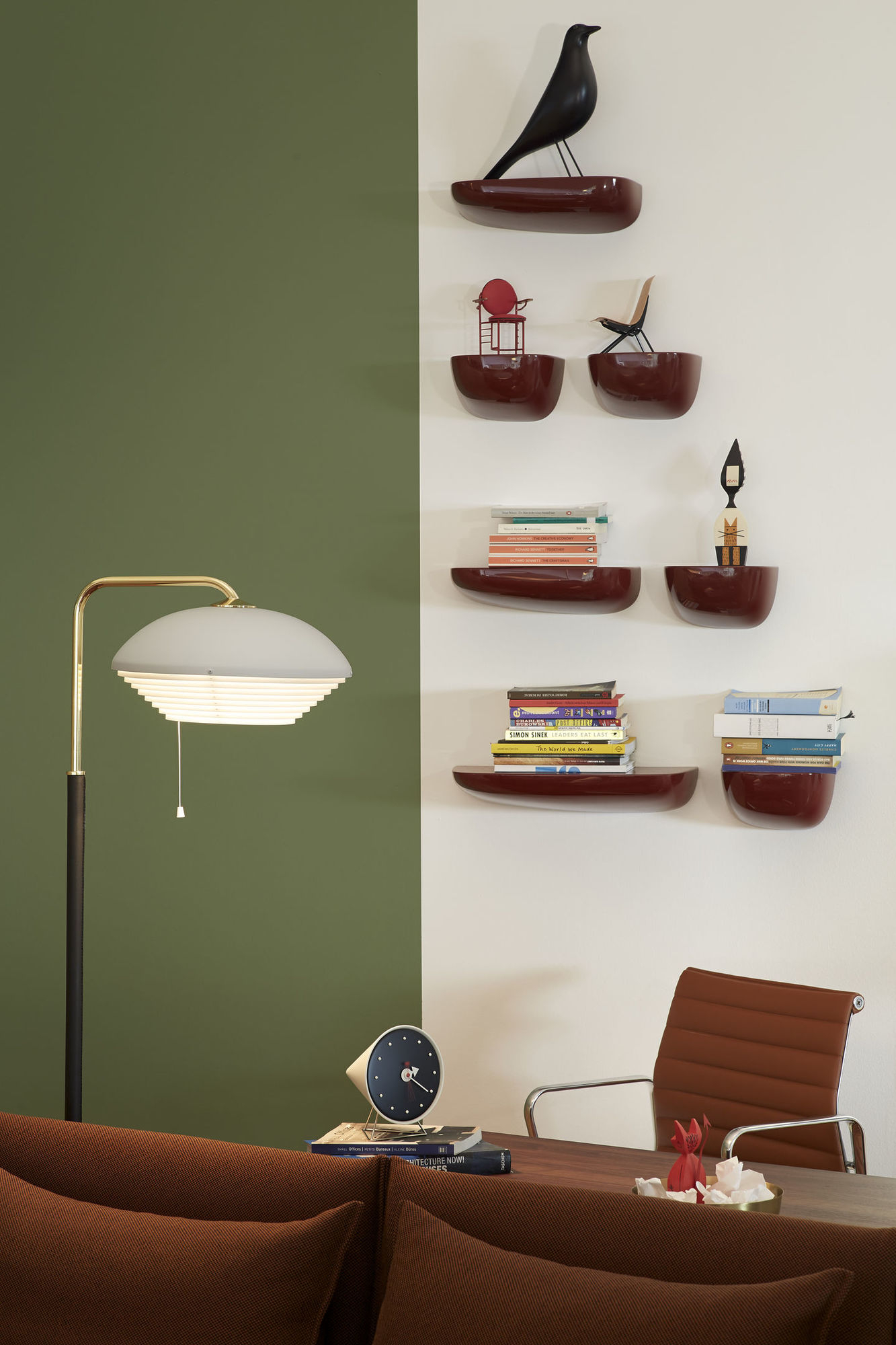Wanddekoration mit mehreren bordeauxroten Corniches Wandboards von Vitra, die Bücher und Deko-Objekte halten.