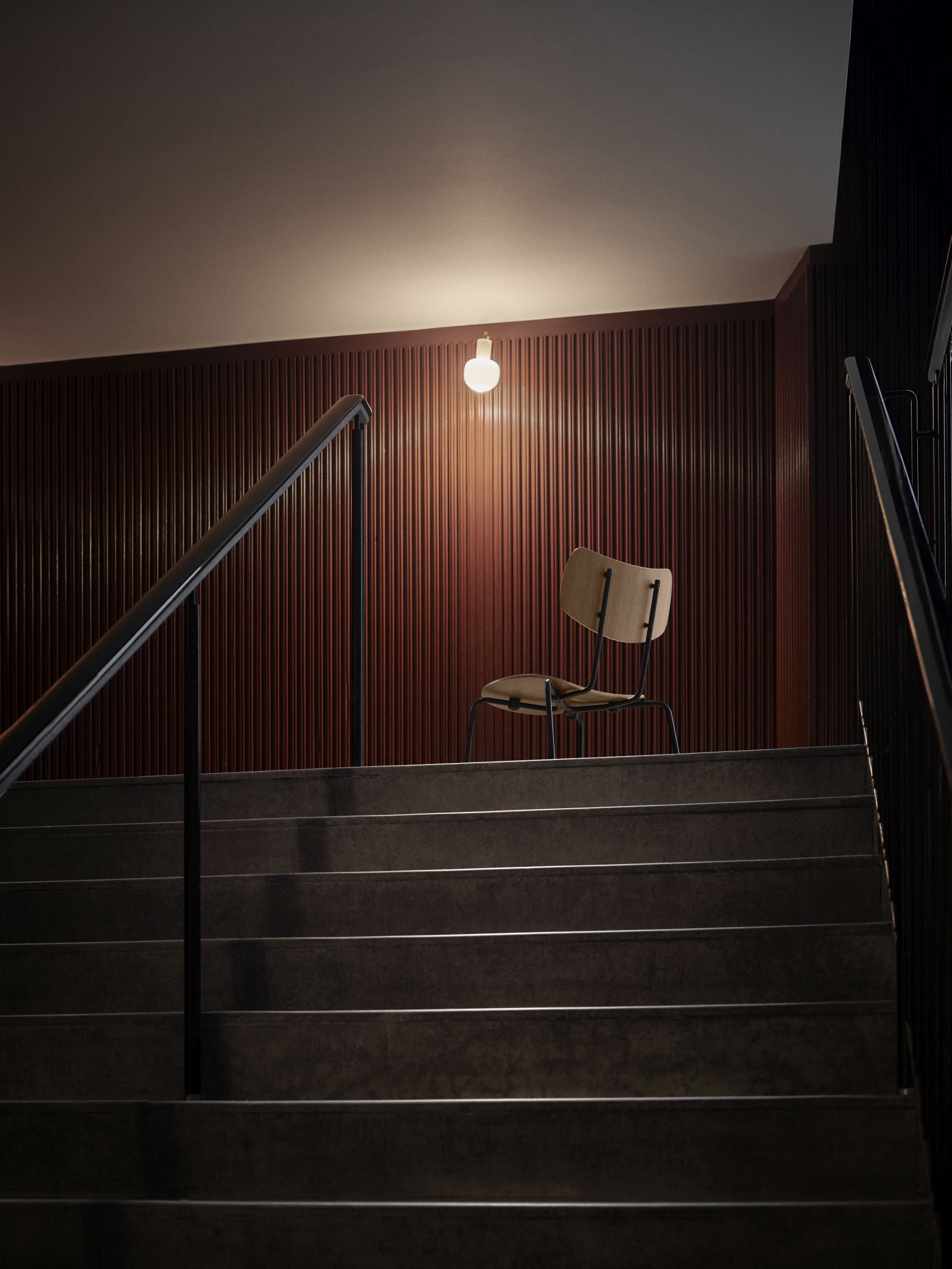 Vega Chair von Carl Hansen & Søn auf einer Treppe vor einer Wand.