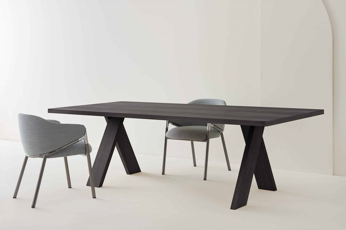 Artful Wood Table von Segis: Dunkler Holztisch mit X-förmigem Gestell und zwei Stühlen.