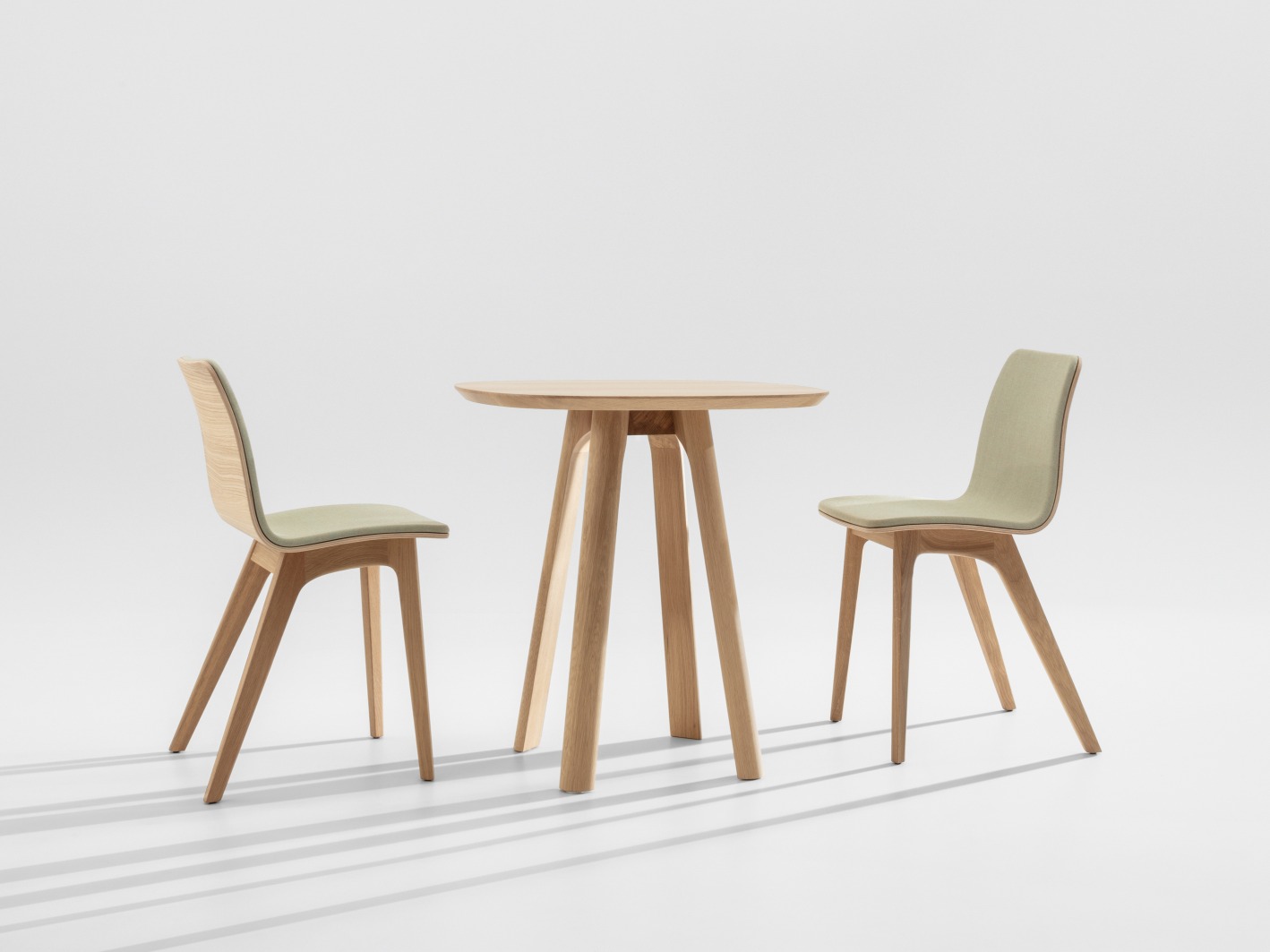 Morph Holzstuhl mit Sitzpolster und passender Holztisch, helles Holz, modernes Design.
