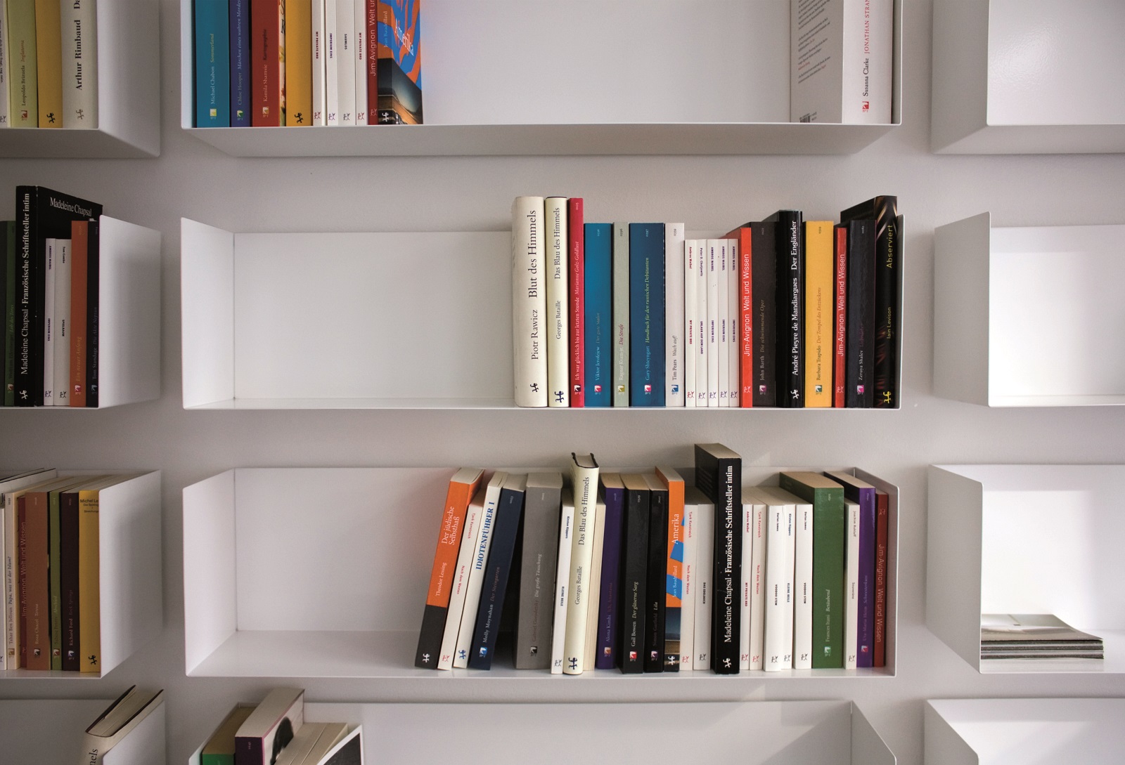 Weiße a Linea1 Regale von Müller Möbelwerkstätten an einer Wand mit Büchern.