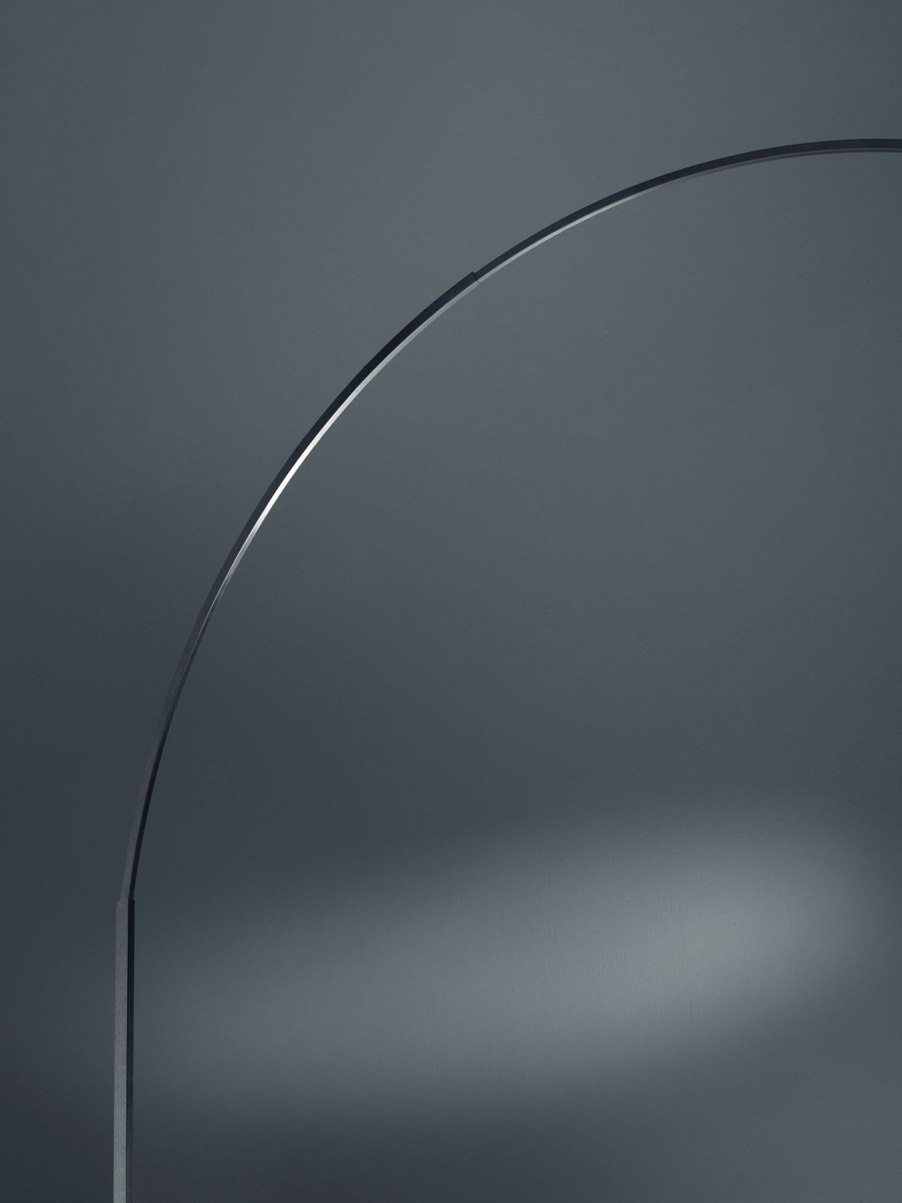 Detailaufnahme der Arco Stehleuchte, ein Designklassiker mit elegantem, gebogenem Leuchtenarm und minimalistischer Ästhetik.