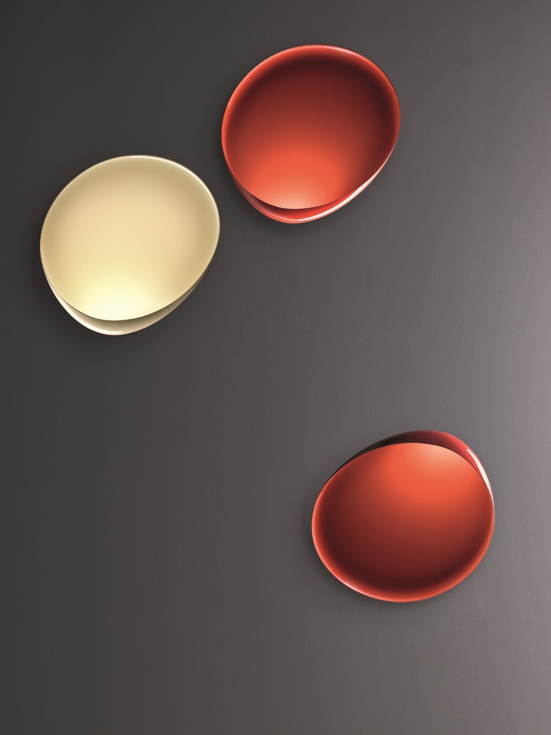 Lake Wandleuchte von Foscarini: Drei moderne, farbige Wandlampen in Rot und Beige.