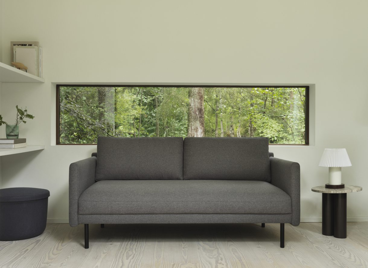 Graues Sofa mit Normann Copenhagen Dit Coffee Table Beistelltisch und Lampe in minimalistischem Wohnzimmer.