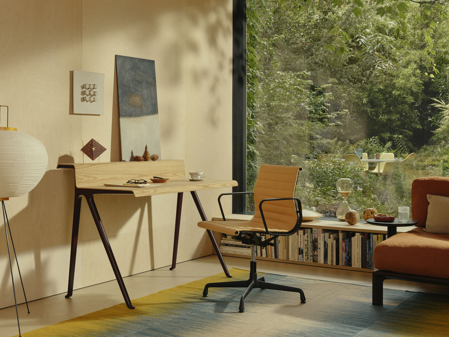Vitra Courier Schreibtisch aus hellem Holz mit dunklen Beinen in modernem Arbeitszimmer.