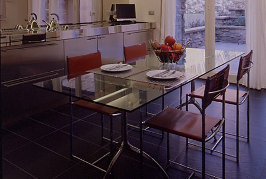Spaghetti Chair 101 Stuhl in Schwarz mit transparentem PVC an Esstisch mit Glasplatte.