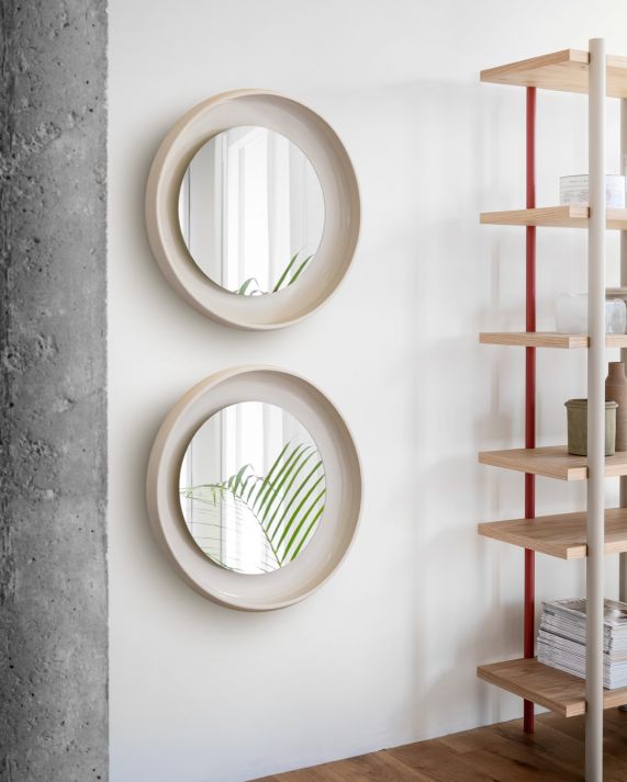 Zwei runde Coque Spiegel mit Keramikrahmen von Miniforms an einer weißen Wand.