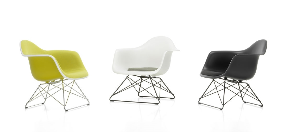 Drei Eames Plastic Arm Chairs LAR von Vitra in Gelb, Weiß und Schwarz mit Sitzpolster.