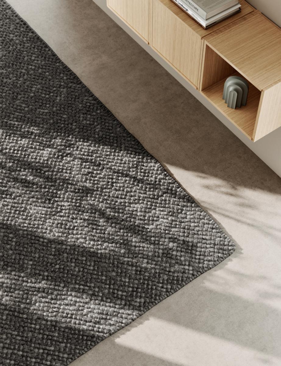 Detailaufnahme des dunkelgrauen Tact Rug Teppichs von Woud, 90x140 cm, mit Textur.