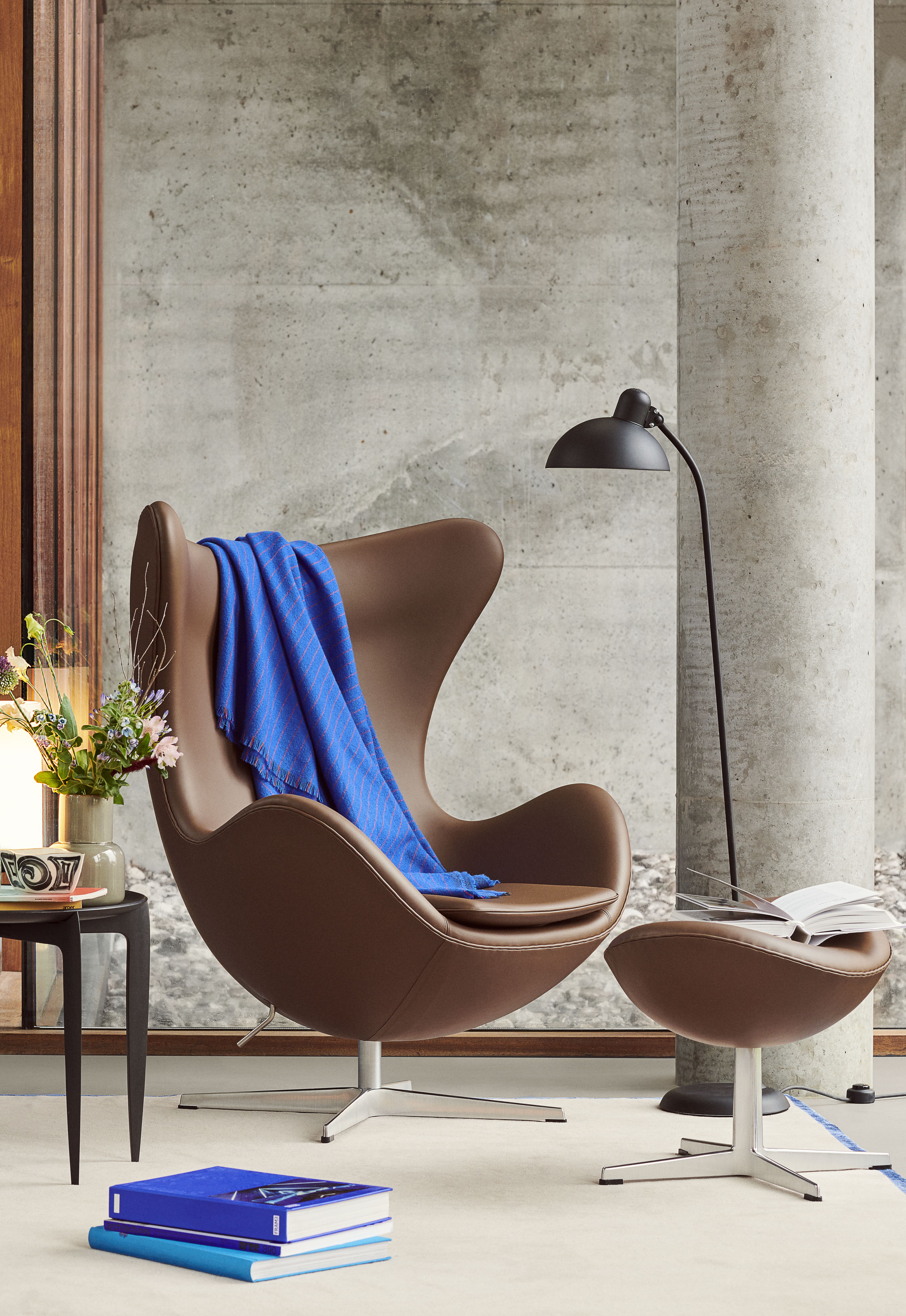 Brauner Egg Chair Sessel mit Hocker und blauer Decke, Designklassiker von Fritz Hansen.