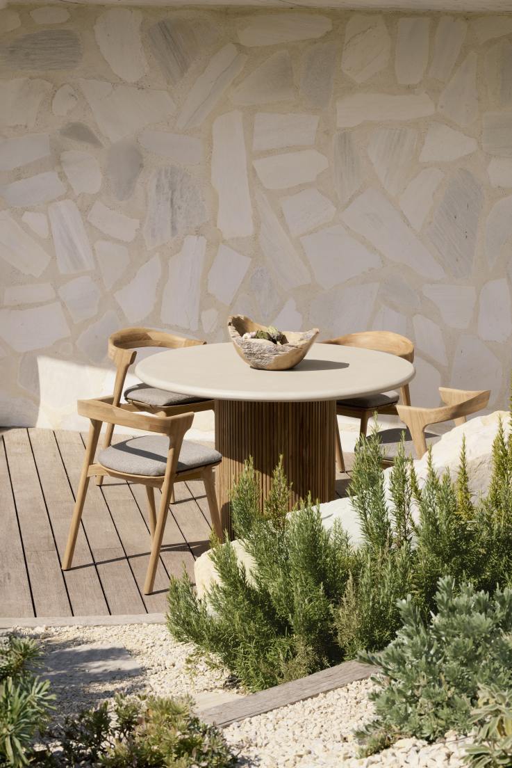 Ethnicraft Roller Max Outdoor Esstisch mit vier Holzstühlen auf einer Terrasse mit mediterraner Dekoration.