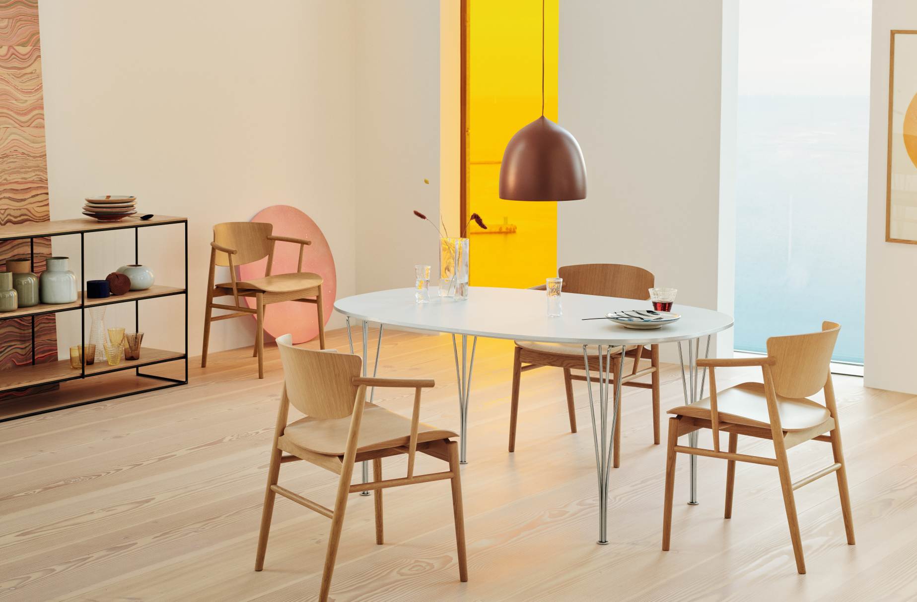 Esszimmer mit weißem Super Elliptisch Tisch von Fritz Hansen und Holzstühlen unter einer Pendelleuchte.