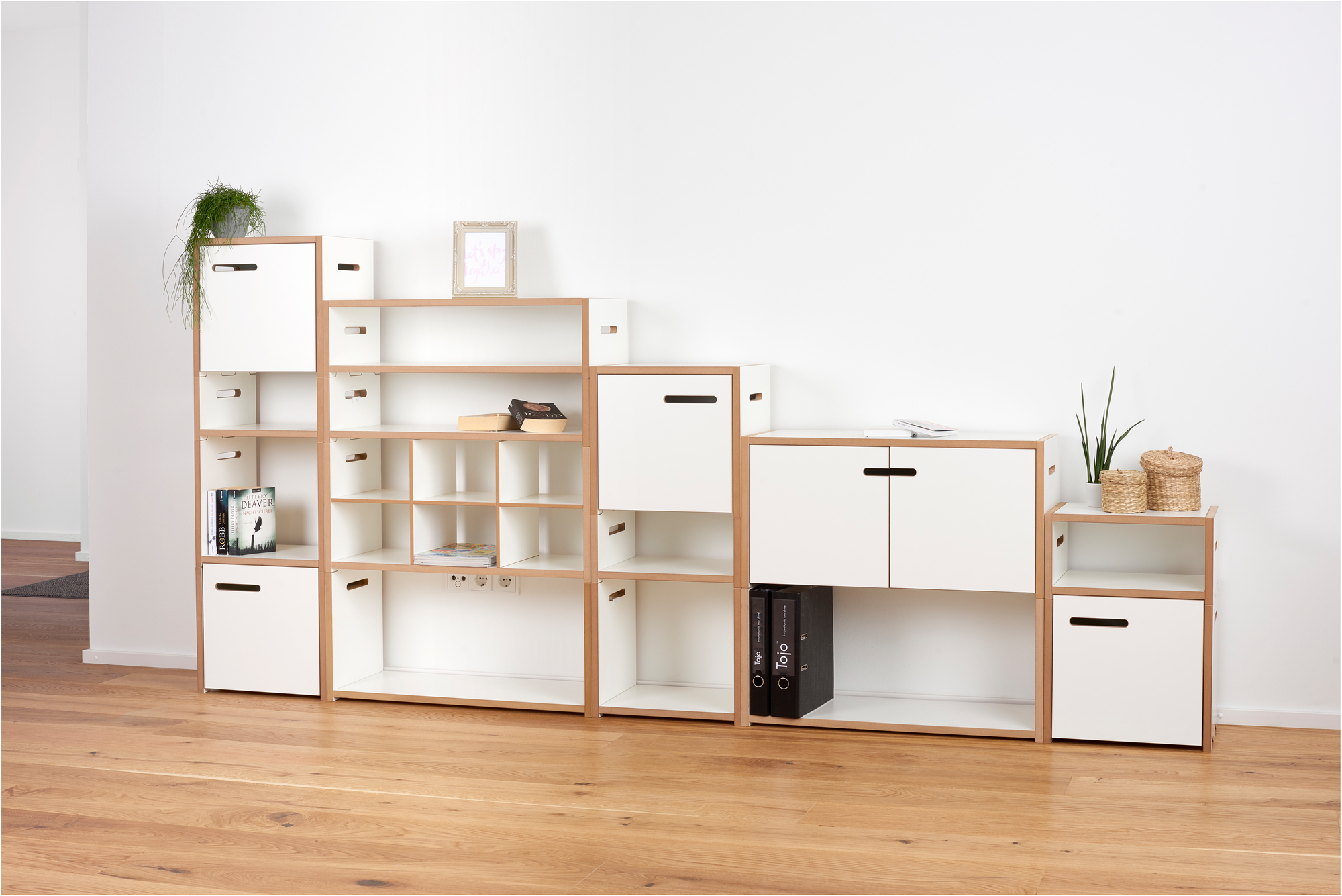 Tojo Hochstapler Regalsystem mit weißen Einsätzen und Holzrahmen, flexibles modulares Möbel für Wohnzimmer und Büro.