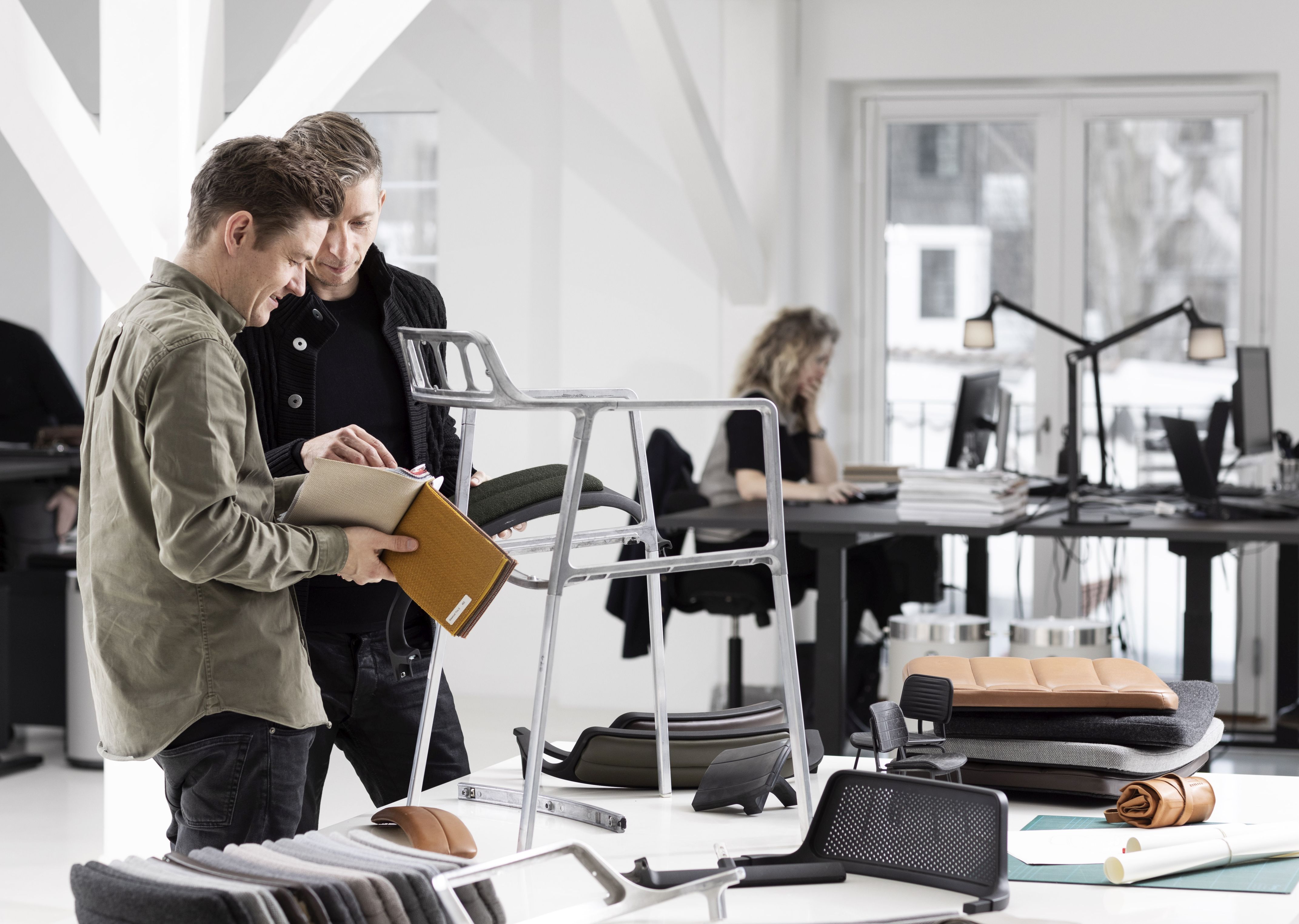 Vipp Stuhl sandfarbenes Anilinleder: Detailaufnahme von Stuhlkomponenten und Farbmustern im modernen Büro. Hochwertige Ledermöbel für stilvolles Wohnen.