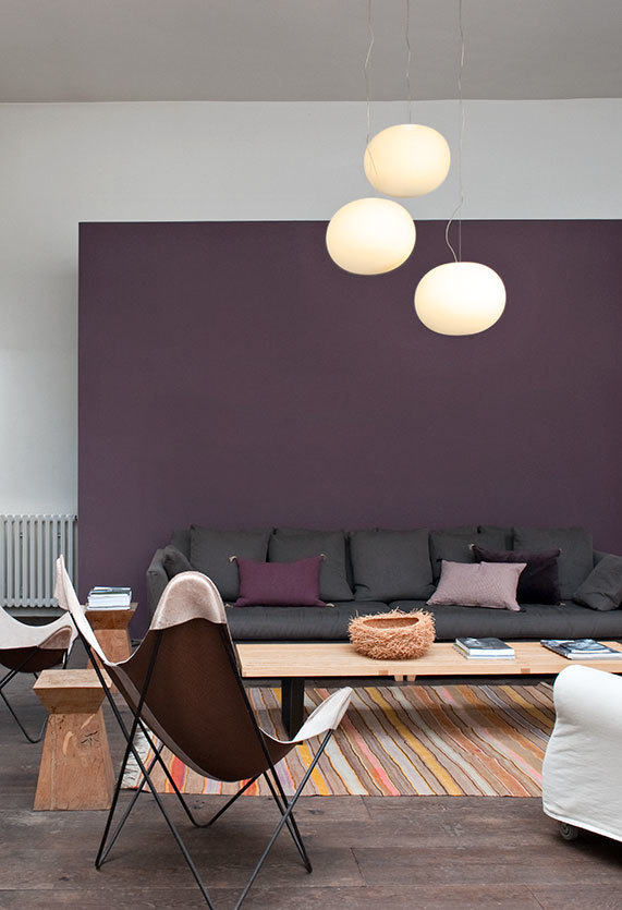 Wohnzimmer mit Glo Ball Hängeleuchten von Flos, die ein warmes Licht spenden.