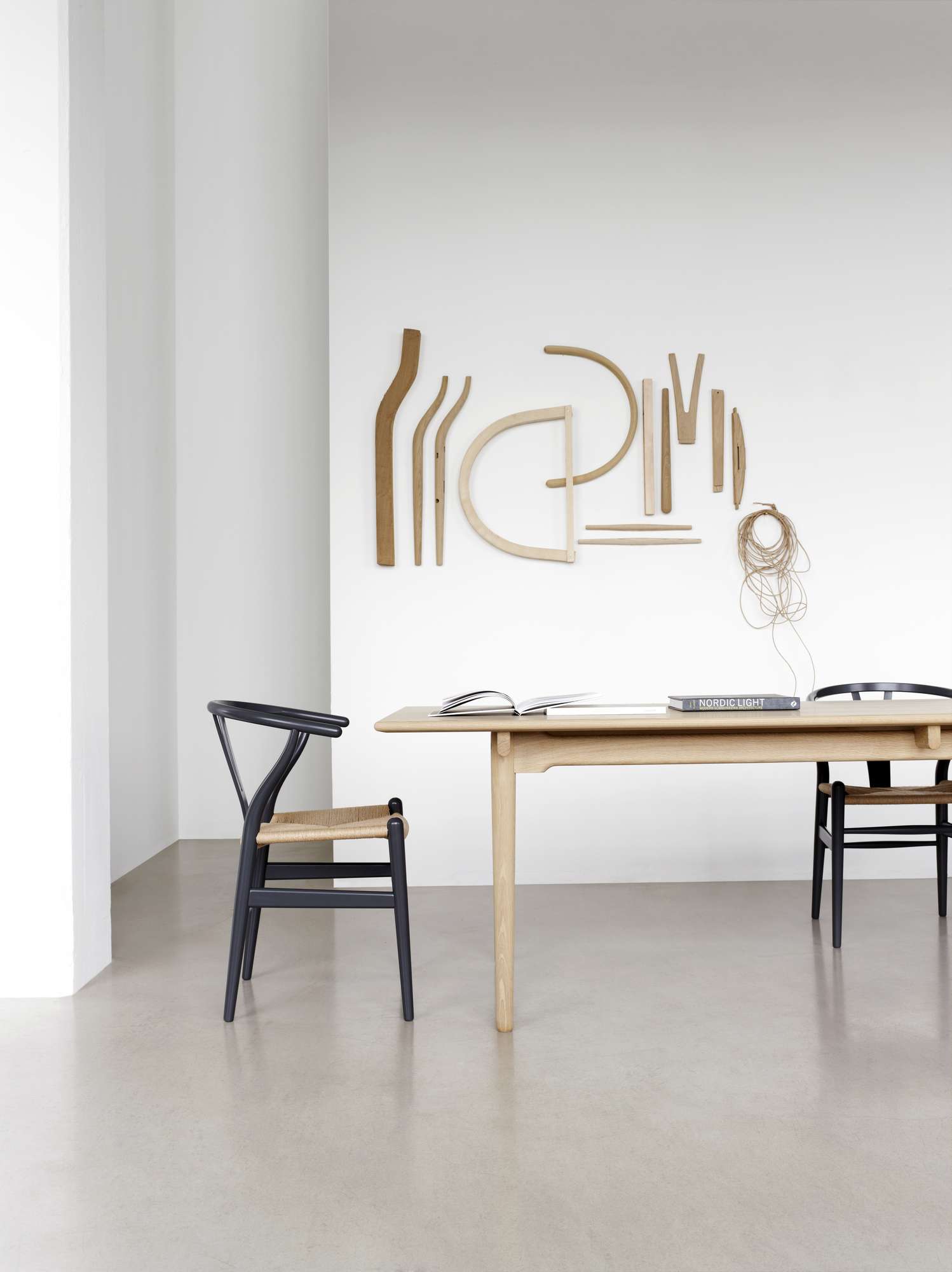 CH327 Tisch von Carl Hansen & Søn mit zwei schwarzen Y-Stühlen in minimalistischem Raum.