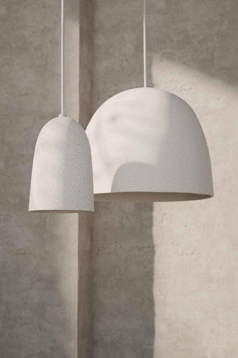Zwei Ferm Living Pendelleuchten mit gesprenkelter Oberfläche in Weiß, unterschiedliche Größen und Formen.