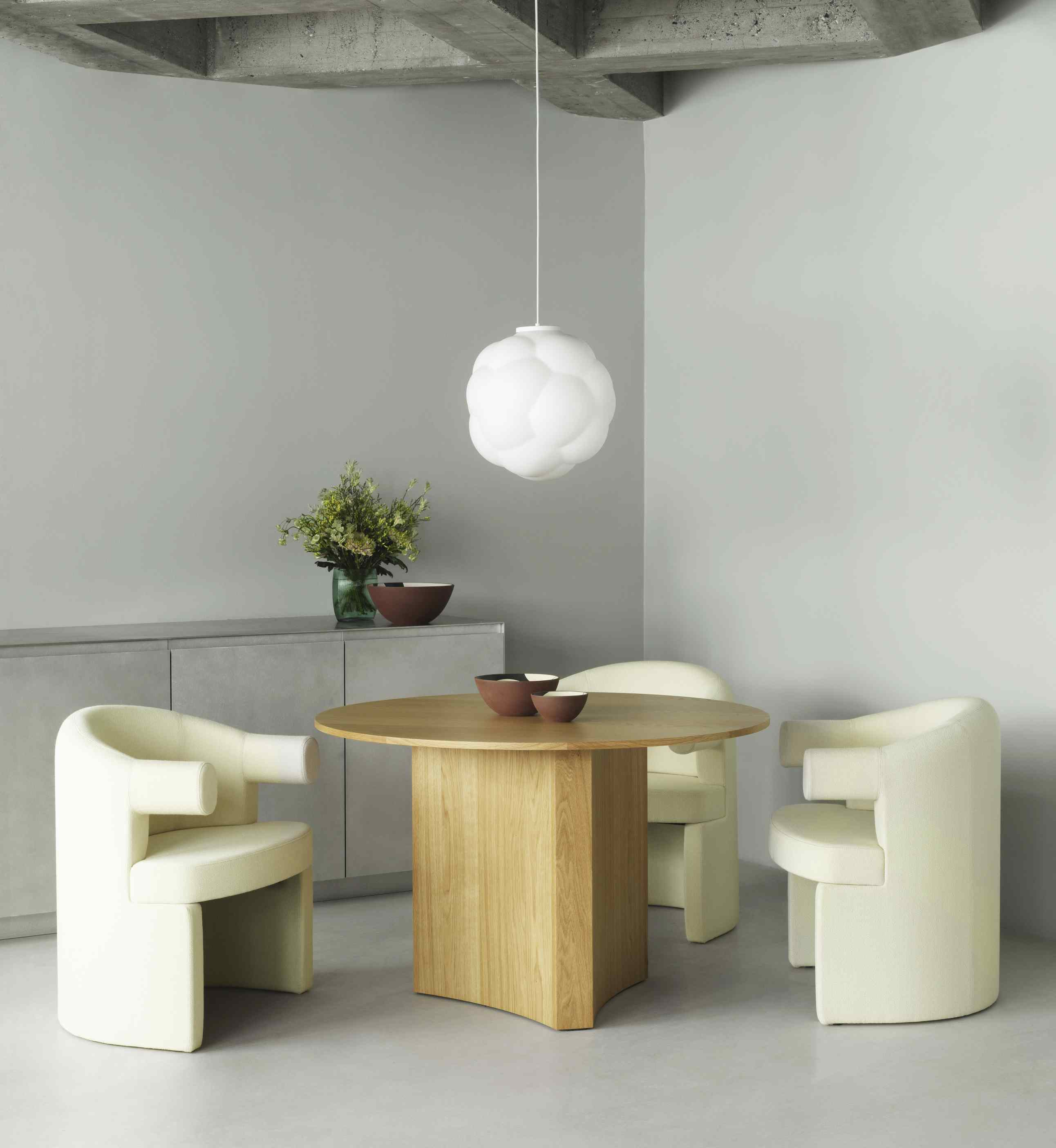 Weiße Bubba Pendelleuchte von Normann Copenhagen über Esstisch mit Stühlen. Moderne Innenraumbeleuchtung.