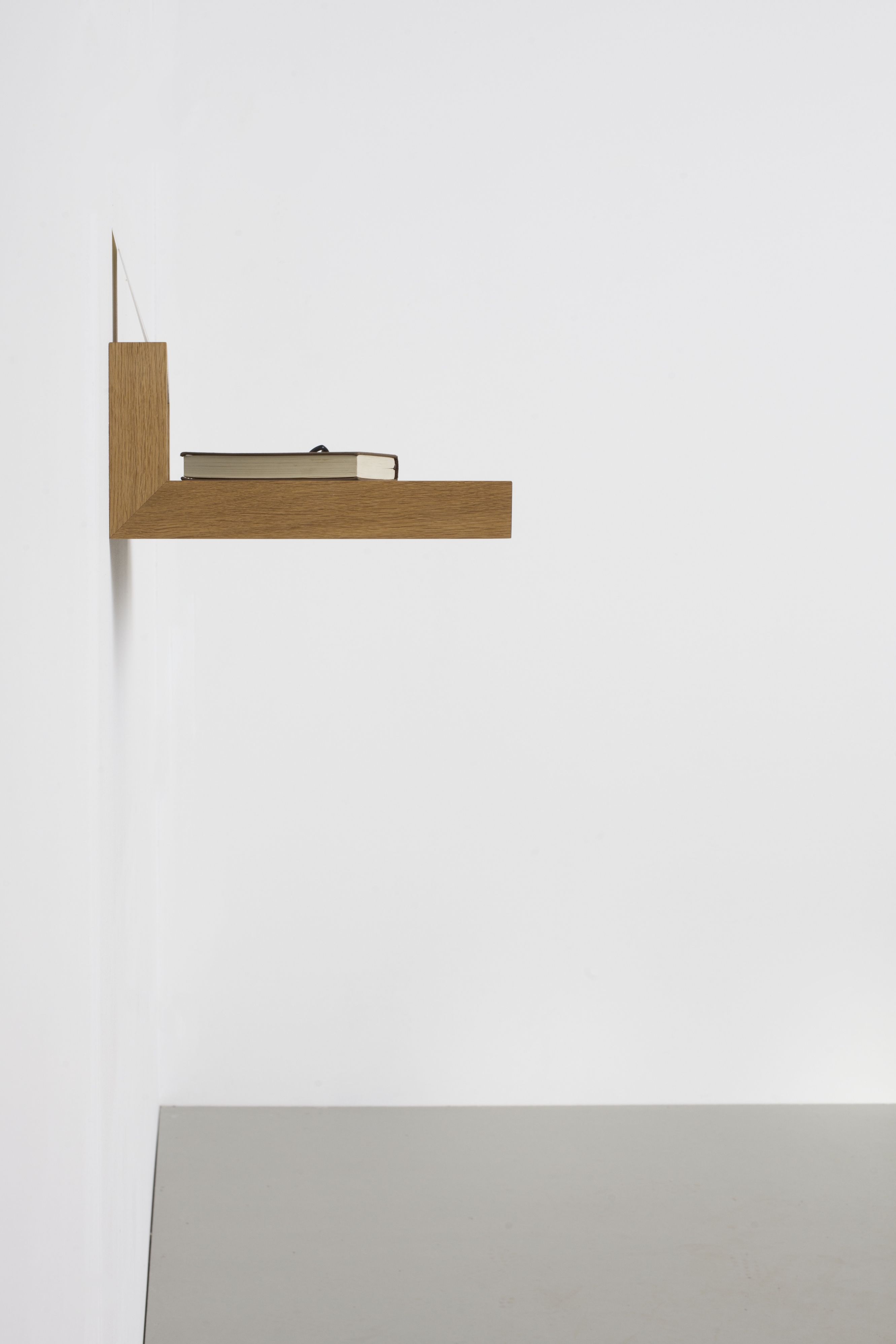 Nahaufnahme des Ablageboards buck1 von das kleine b mit Buch an weißer Wand.