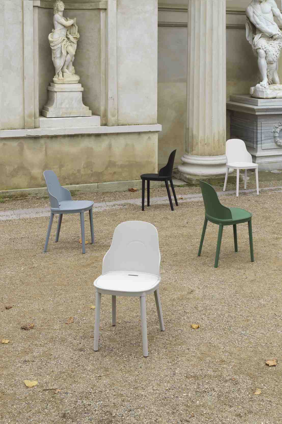 Fünf Allez Chair PP Stühle von Normann Copenhagen in verschiedenen Farben vor klassischer Architektur.