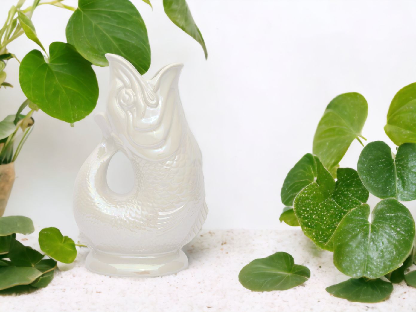 Weisse, schimmernde Fisch-Vase aus Keramik, dekorative Blumenvase für Zuhause und Garten, Nahaufnahme.