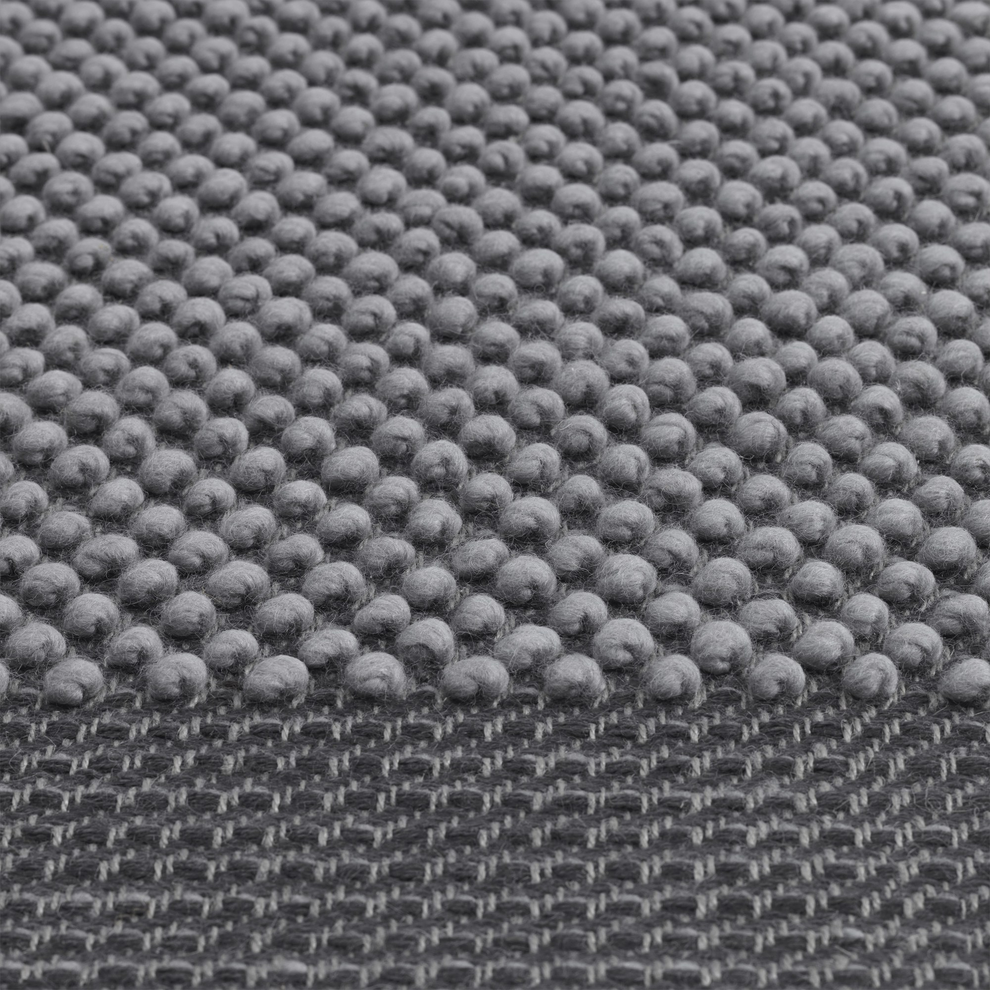 Detailaufnahme des grauen Muuto Pebble Rug Teppichs mit auffälliger Noppenstruktur und gewebtem Untergrund.