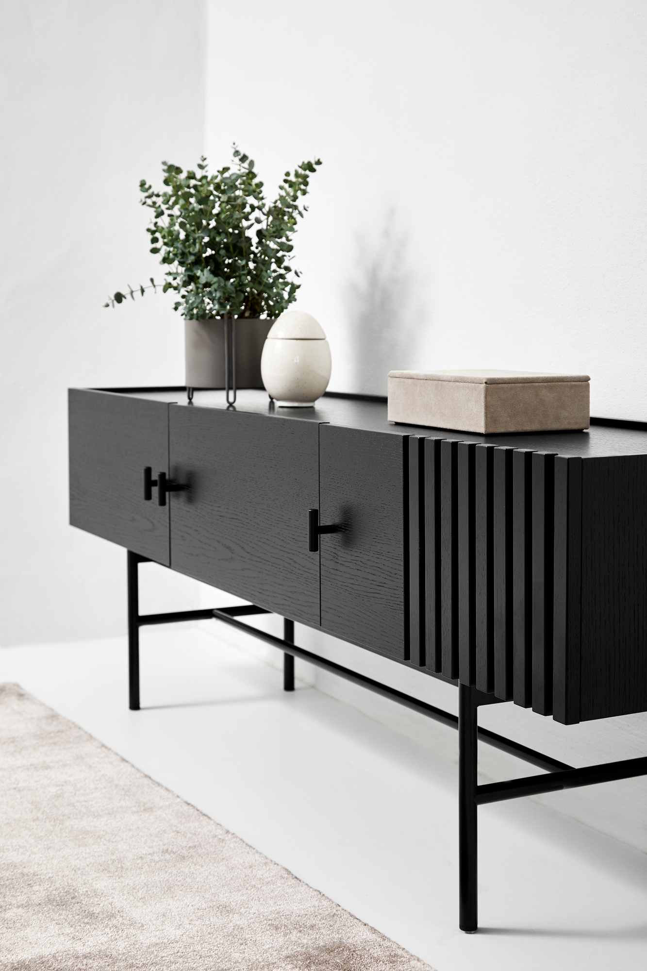 Schwarzes Array Sideboard von Woud, 150cm breit, mit Pflanze und Dekobox auf der Oberfläche.