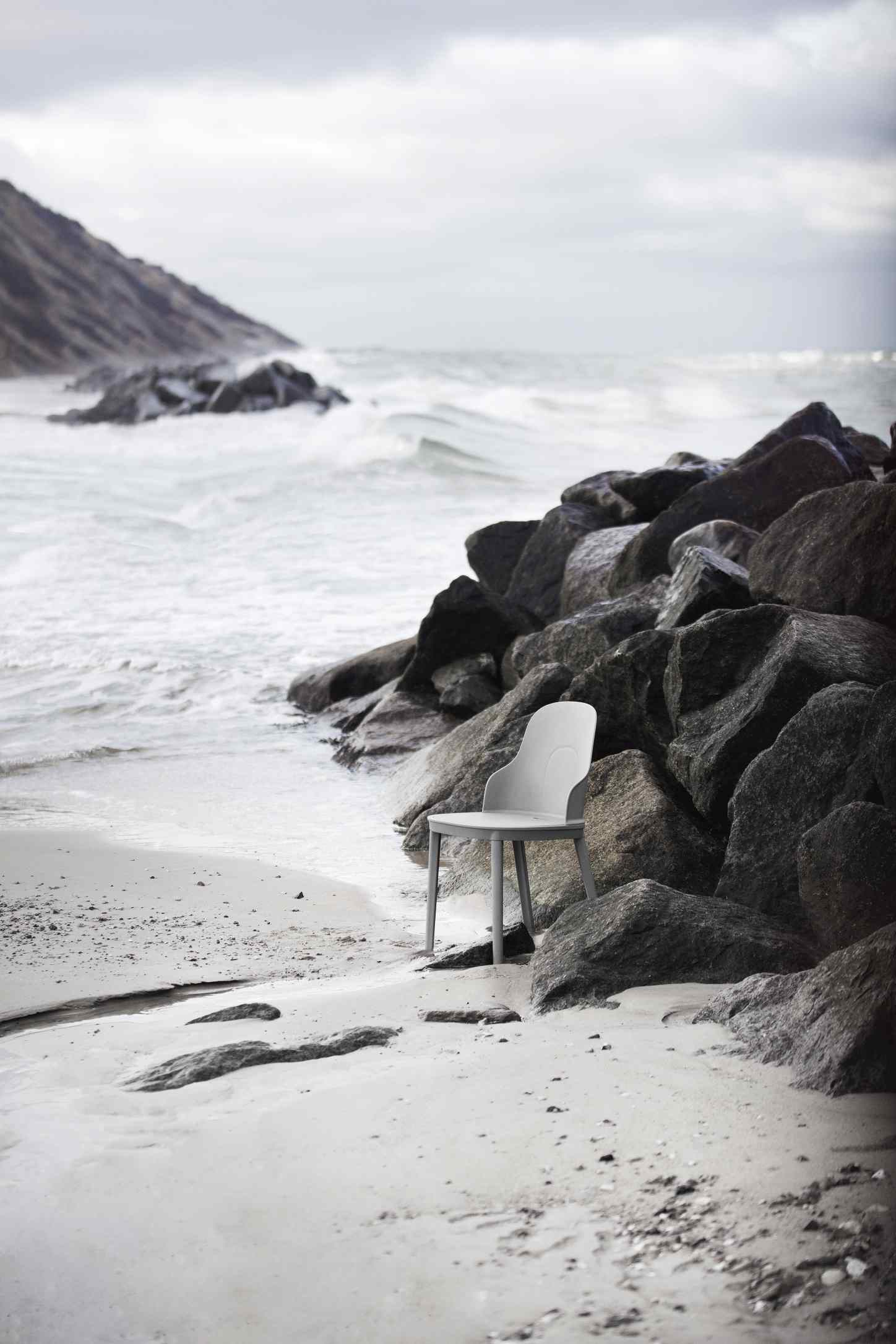 Allez Chair von Normann Copenhagen, grauer Design Stuhl am Strand zwischen Felsen.