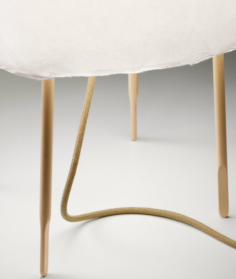 Detailaufnahme der Kurage Tischleuchte von Foscarini mit hellem Schirm und Holzbeinen.